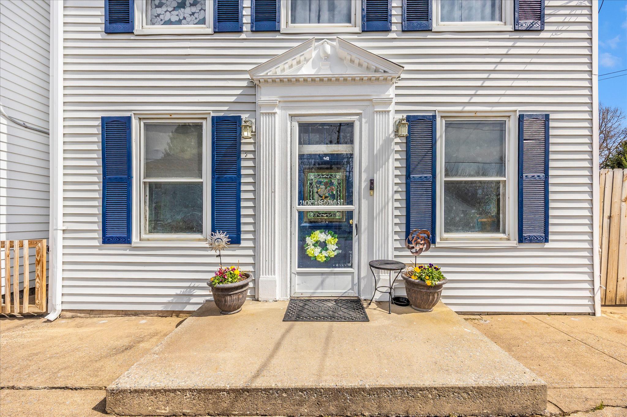 * Motivated Seller-  Ask about available Closing Cost Assistance with Acceptable Offer* Welcome to 2 North 2nd St in Woodsboro. Historic character and small town charm meet everyday convenience at this lovingly maintained home. The location offers quick access to commuter routes including Route 26, Route 15, and Route 70, making it an easy drive to Wegmans, Super Walmart, and downtown Frederick while enjoying the comfort of a small town setting. The inviting front living area is filled with natural light and highlighted by dramatic decorative ceiling panels and fresh luxury vinyl plank flooring. The kitchen features Corian countertops, 42 inch wood cabinetry, an island and generous storage with direct access to the covered porch and fenced outdoor space. Just beyond is a comfortable gathering room with hardwood floors, wood fireplace and a recently updated half bath. A spacious rear recreation room provides excellent flexibility for a home office, fitness area, or additional living space. Upstairs you will find three well appointed bedrooms including one with a private en suite bath featuring an updated tile shower and fixtures. The primary suite includes a large walk in closet and direct access to the covered second story porch. A spacious laundry room with additional storage is conveniently located on the bedroom level. Outside, enjoy your private oasis with a fully fenced yard, koi pond, a separate summer kitchen that works well for storage or hobbies, and an attached garage with private driveway parking, a rare convenience for homes near the center of town. Recent improvements include a new furnace, new oil tank, and updated electrical service and panels. Enjoy walkable access to local schools, restaurants and Woodsboro park where you can take advantage of playgrounds, trails, and year round community events. Homes with this level of historic character and convenient location rarely become available. Schedule your tour today.
