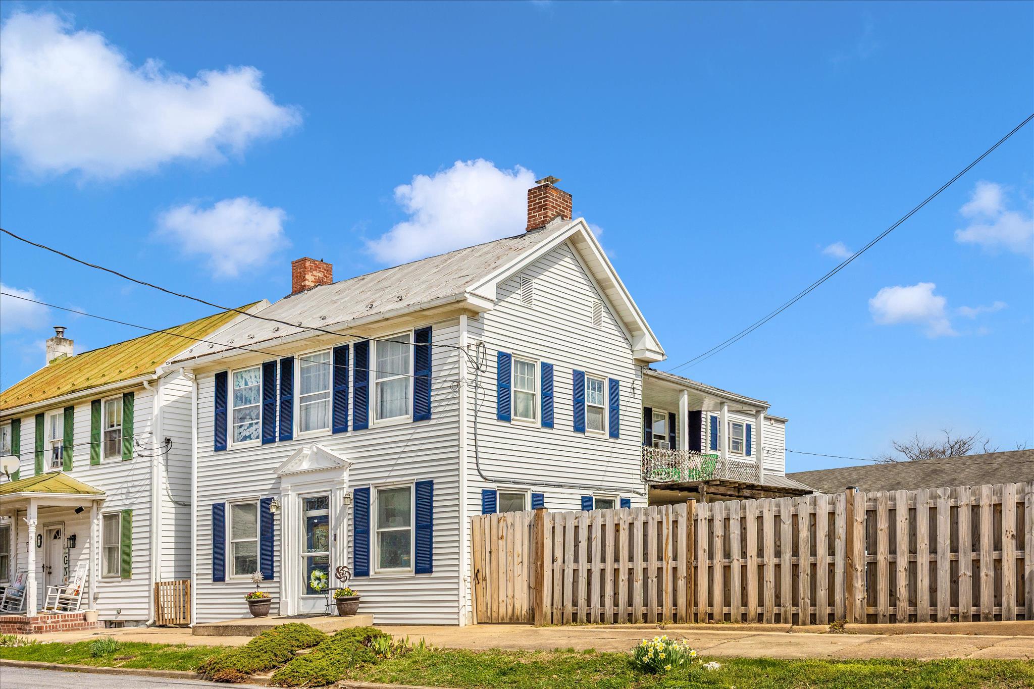 * Motivated Seller-  Ask about available Closing Cost Assistance with Acceptable Offer* Welcome to 2 North 2nd St in Woodsboro. Historic character and small town charm meet everyday convenience at this lovingly maintained home. The location offers quick access to commuter routes including Route 26, Route 15, and Route 70, making it an easy drive to Wegmans, Super Walmart, and downtown Frederick while enjoying the comfort of a small town setting. The inviting front living area is filled with natural light and highlighted by dramatic decorative ceiling panels and fresh luxury vinyl plank flooring. The kitchen features Corian countertops, 42 inch wood cabinetry, an island and generous storage with direct access to the covered porch and fenced outdoor space. Just beyond is a comfortable gathering room with hardwood floors, wood fireplace and a recently updated half bath. A spacious rear recreation room provides excellent flexibility for a home office, fitness area, or additional living space. Upstairs you will find three well appointed bedrooms including one with a private en suite bath featuring an updated tile shower and fixtures. The primary suite includes a large walk in closet and direct access to the covered second story porch. A spacious laundry room with additional storage is conveniently located on the bedroom level. Outside, enjoy your private oasis with a fully fenced yard, koi pond, a separate summer kitchen that works well for storage or hobbies, and an attached garage with private driveway parking, a rare convenience for homes near the center of town. Recent improvements include a new furnace, new oil tank, and updated electrical service and panels. Enjoy walkable access to local schools, restaurants and Woodsboro park where you can take advantage of playgrounds, trails, and year round community events. Homes with this level of historic character and convenient location rarely become available. Schedule your tour today.