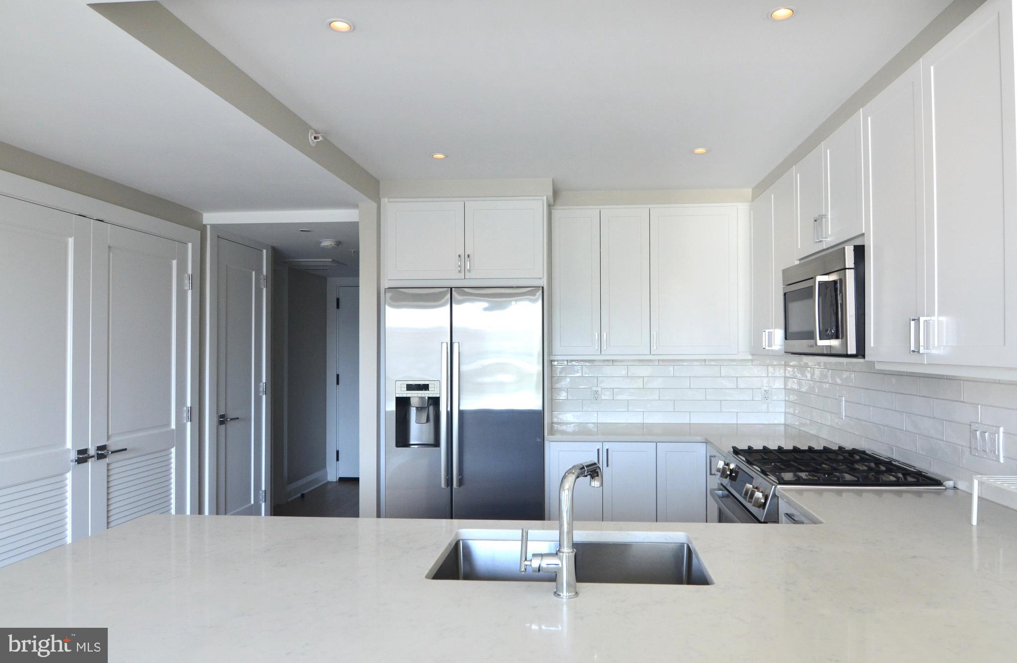 Elegant and charming one bedroom + den at the luxury VENUE condominium in Old Town Alexandria. Built in 2022, this attractive and smartly designed floor-plan optimizes space and flow so it appears larger than the actual 750 sq ft size. A stylish and spacious modern kitchen with white cabinetry, beautiful backsplash, Bosch appliances and large peninsula countertop offers the ideal room for cooking enjoyment. A built-in closet system also supports a well-organized lifestyle. A den with a sliding barn door and custom-built bookcase also offers an ideal flex space for use as a home office, guest bedroom or exercise room. At the VENUE, advantageous amenities, convenient living, delicious eating and adventure await! A full-service concierge and building manager are on-site to support residents’ everyday needs and great restaurants and shopping are close by. Have fitness goals? Make the most of the building’s state-of-the-art fitness center, step right outside for easy access to the Mount Vernon Trail, and store your bike in the bike room. Public tennis courts are also just across the street. Enjoy entertaining? Host guests at the building’s Rooftop Terrace with its outdoor grilling station and fire pit seating area or at the Owner’s Sky Lounge equipped with a fireplace, cocktail bar and flat-screen TVs. The building is also LEED Certified supporting greater energy efficiency. This amazing one bedroom + den is MUST-SEE and immediate occupancy is available. Make an appointment today to visit your stunning future home.