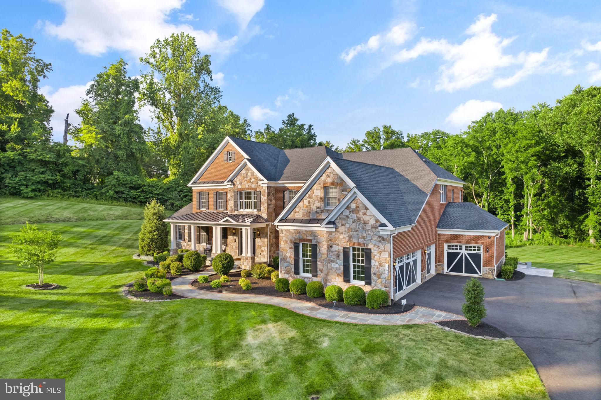 PRICE IMPROVEMENT !! Western Loudoun County provides the setting for this exquisite, 8400+ square feet luxury home in the sought-after Shenstone Reserve community.  Encompassing 3.61 acres of green grass, towering trees, landscaped walkways, a huge TREX deck, an expansive patio with sitting walls, and an outdoor kitchen, all perfect for entertaining.  After dark, the landscape comes alive with magnificent outdoor lighting, providing ambiance for your next dinner party.  Beautifully sited, the magnificent all-brick, Toll-Brothers ‘Hampton’ model residence overlooks a gorgeous flat backyard, ready for your pool.  In the front of the home is a covered porch with inviting views of the surrounding landscape.
 
A stately yet gracious presence, this classic colonial-style home provides over 8,400 square feet of spectacular living space on two levels, plus a superbly finished space on the lower walk-out level. Built with extraordinary quality and craftsmanship, this stunning residence is exquisitely appointed and in pristine condition.  A grand two-story foyer with dual, curved staircases welcomes you into the home. 8-foot doorways, 9-foot ceilings, hardwood floors, exquisite crystal light fixtures, and wrought iron accents create a simple, sophisticated, and elegant style. There are five bedrooms, six full baths, and a half bath. All the rooms are grand and charming, with multiple windows to provide natural sunlight and picturesque views.  The interior includes an impressive entryway, an open layout, natural lighting, and neutral decor. A state-of-the-art gourmet kitchen boasts GE Monogram stainless appliances (including a 6-burner range), marble countertops, a farmhouse-style kitchen sink, a huge center marble-topped island with bar seating (bar stools convey), and a large breakfast area.  

Access to the 4-car garage is in the mudroom with custom cabinetry for all your storage needs and a laundry room with a washing machine and clothes dryer.  Adjacent to the kitchen is an incredible family room with soaring, coffered ceilings, a floor-to-ceiling stone gas fireplace, and a rear staircase to the second level.  Off the family room is a natural light-filled office, with custom bookcases and a built-in window seat.  The gorgeous light-filled side conservatory makes the ideal spot to read or enjoy a glass of wine.  The living and dining rooms have coffered ceilings and plenty of natural light.  The large, elegant dining room is adorned with a decorative stone wall, perfect for family dinners and entertaining.  

The luxurious primary bedroom on the second level is complete with a sitting room, a custom dry bar, and two spacious walk-in closets. The spa-like ensuite bathroom has dual vanities with granite countertops, dual water closets, a large glass-enclosed dual shower head shower, and a huge, jetted whirlpool.  Three additional ensuite bedrooms ensure every family member enjoys unparalleled comfort and privacy.

The fully finished walk-out lower level is spacious and offers plenty of space to play and entertain. It features a huge recreation room, a fifth bedroom with an ensuite bathroom, and a living room, perfect for multigenerational families.

An array of exceptional features elevates the living experience to new heights. No detail has been overlooked, from the Control4 home automation system, the Generac whole-home generator, and the high-tech security system to the whole-home surge protector.
The yard is leveled and is ideal for a pool.  The 3.61 acre property extends beyond the grass area, crosses a creek and ends at Dry Mill Road.

This house is ideally located on the W&OD Trail and just minutes from Route 7, the Greenway, and Historic Leesburg.  Dulles International Airport is conveniently only 20 minutes away.  Many of Loudoun County’s best wineries and breweries are nearby, and they are just waiting to be explored!  This exceptional property is a must-see!