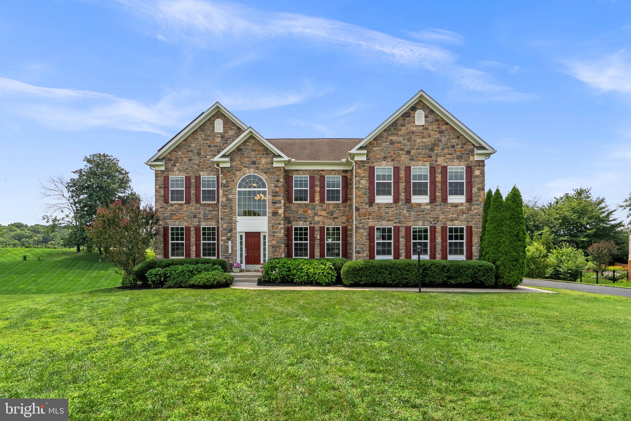 Nestled on over a picturesque acre in the desirable Belle Haven Estates community, this stunning Colonial showcases a timeless stone façade accented by rich burgundy shutters, lush professional landscaping, and a long private driveway. Offering 6,459 finished square feet, the home features a thoughtfully designed traditional floor plan, hardwood floors, recent interior updates including newly installed carpet, and an entertainer's dream backyard. // A grand two-story foyer creates a memorable first impression and is flanked by an elegant formal living room and a formal dining room enhanced with classic wainscoting, chair rail molding, and a timeless chandelier. At the heart of the home, the spacious eat-in kitchen is beautifully appointed with stainless steel appliances, including a refrigerator replaced in 2024, granite countertops, a center island with seating, pendant lighting, a subway tile backsplash, a built-in writing station, and a breakfast bar overlooking the sun-filled breakfast room with access to the rear deck. Just beyond, the bright breakfast room offers another inviting space to relax with direct deck access, while a conveniently located laundry room completes this wing of the main level. // Open to the kitchen, the breathtaking two-story family room impresses with soaring coffered ceilings, expansive lower windows topped by dramatic arched upper windows, and a striking floor-to-ceiling stone gas fireplace that serves as the focal point of the space. Just off the family room, a private study offers the perfect work-from-home space and is complemented by a dual-entry full bathroom, accessible from both the study and hallway, featuring recently updated lighting and mirror. // Ascend to the upper level, where a lofted hallway overlooking the family room leads to the luxurious Owner's Suite. This private retreat features hardwood flooring, an elegant tray ceiling, a spacious dressing area, a large walk-in closet, and a separate sitting room framed by decorative columns and complete with a granite-topped wet bar. The spa-inspired ensuite bathroom offers dual vanities, a corner soaking tub, and a frameless glass-enclosed shower. Three additional bedrooms complete the upper level. Two share a convenient dual-entry full bathroom, while the fourth bedroom features its own private ensuite bathroom and a walk-in closet. // The fully finished lower level expands the home's exceptional living space with luxury vinyl tile flooring throughout an expansive recreation room, providing endless possibilities for a media room, game room, or additional lounge area. A versatile bonus room is ideal for a home gym, hobby room, or flex space, while a spacious fifth bedroom with exterior access to the pool patio and a full bathroom make this level ideal for guests or multigenerational living. Two generous storage and utility rooms, along with a water heater replaced in 2023, complete the lower level. // Designed for both entertaining and everyday enjoyment, the backyard is a true private retreat. The expansive deck overlooks a heated, fenced, and filtered saltwater in-ground pool surrounded by a spacious patio, with a shaded lounge area beneath the deck for relaxing on warm afternoons. Beyond the pool, the large fenced backyard backs to a picturesque farm, providing peaceful pastoral views and an exceptional sense of privacy.