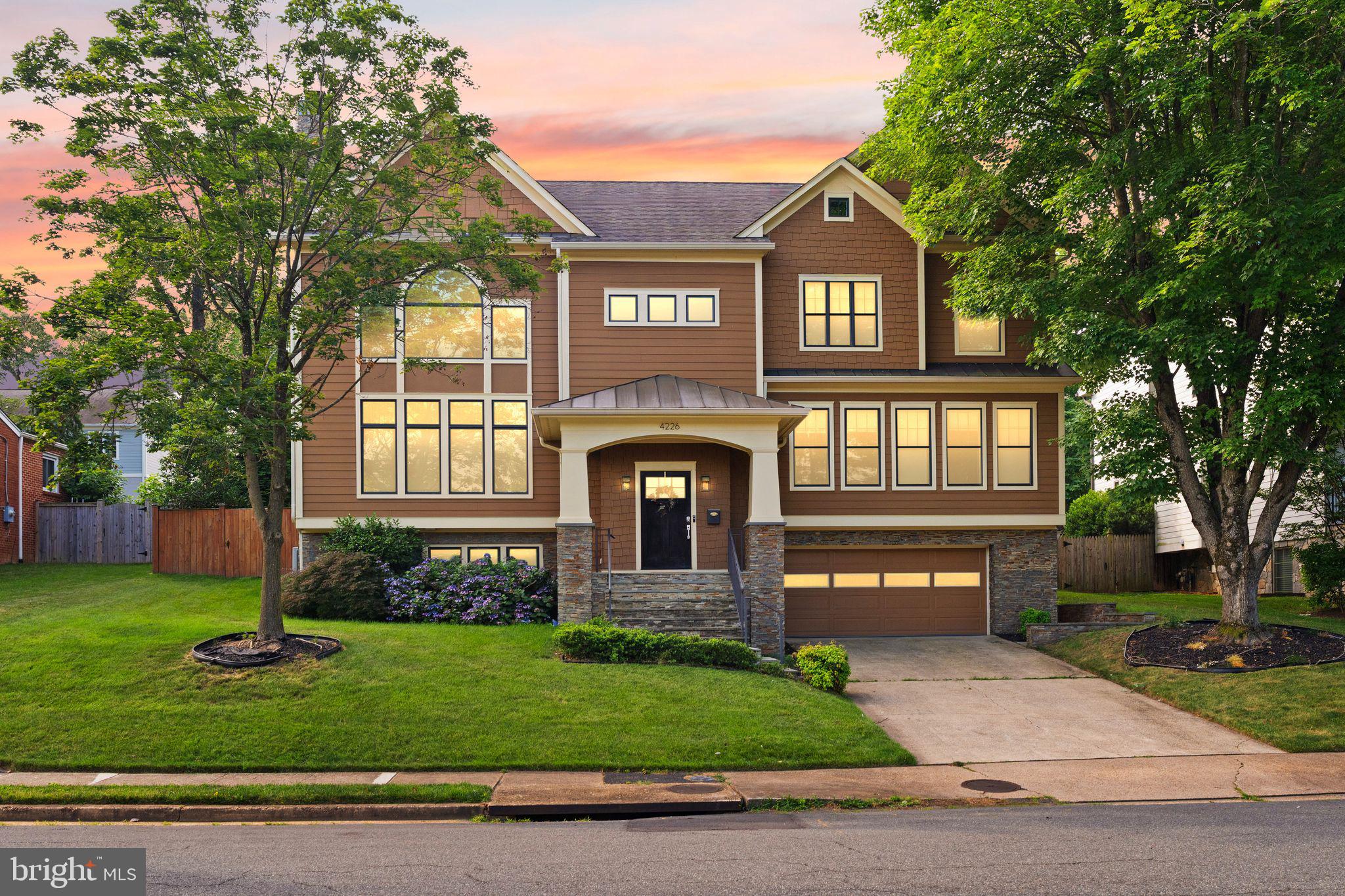 4226 40th St. N, Arlington, VA — Custom-built in 2015, this distinguished home offers 3,600+ sq. ft. across the upper two levels and thoughtful living spaces throughout.

Welcome to dramatic living with a two-story great room anchored by a gas fireplace and oversized Palladian windows that flood the home with natural light. Entertain with ease in the luxury kitchen—large center island, 6-burner stove with hood, and a butler’s pantry/wet bar that flows directly to the formal dining room.

Main level conveniences include a private home office and a main-level bedroom with ensuite bath. Upstairs, a bright loft overlooks the great room—perfect for reading or a quiet retreat. The primary suite features a generous walk-in closet and a spa-like bath with steam shower. A secondary primary-style bedroom is ideally located on the opposite side of the home with its own ensuite and walk-in closet; bedrooms 3 and 4 share an attached bath.

The finished lower level offers a cozy family room with a stone fireplace—ideal for movies, games, and casual gatherings—plus a mudroom that adjoins the garage and lower-level finished spaces.

Piece de resistance: the backyard. A fully covered outdoor entertaining area with outdoor kitchen, beautiful patio, and expansive green lawn create a private oasis for dining, play, and relaxation.

A sophisticated, well-appointed home that blends grand entertaining spaces with comfortable everyday living in desirable Arlington.