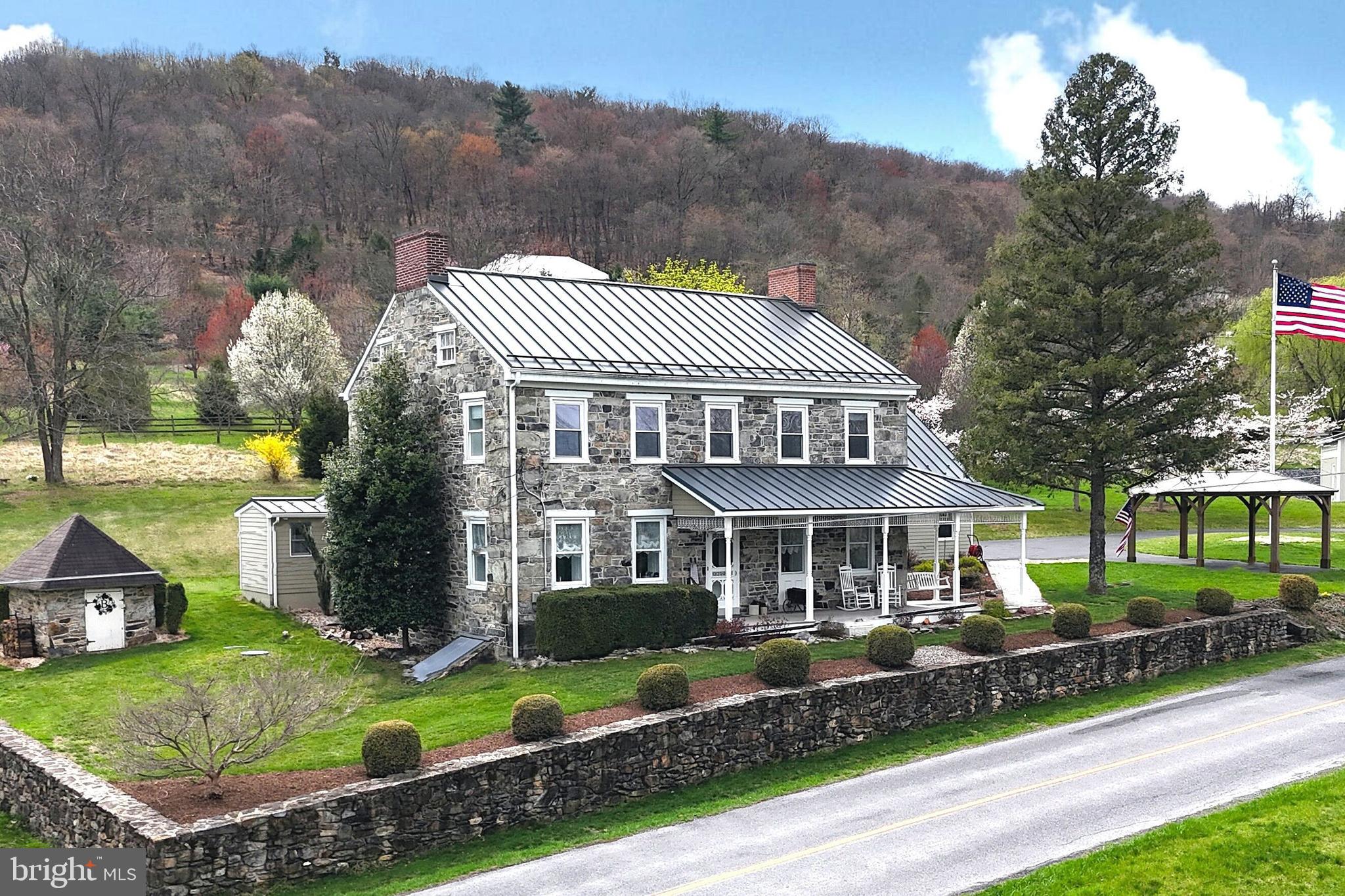 Truly extraordinary property highlighting a complete modernization of this spacious circa 1840 stately, stone home in the middle of Adams County’s picturesque orchard country and just west of historic Gettysburg on almost 3 acres.  Known by historians as The James Linn House, built by the Linn family with large field stones from the original farm, you just don’t find homes like this; pre-civil war era construction & charm, luxuriously upgraded with all the modern conveniences, all while preserving the historic integrity that makes this home so special.  You’ll love those authentic 24” deep window sills, old-tyme fireplaces, stone accent walls, wood floors and spacious bedrooms. No expense has been spared preserving this showpiece while including a highly-efficient tri-zone geothermal HVAC, custom kitchen with granite counters, plumbing, 200A electric, energy-efficient insulation, standing-seem metal roof, double & triple pane windows, luxurious bathrooms, and so much more.  A spacious floor plan provides for a first-floor primary bedroom with an ensuite bathroom and radiant floor heat; comfortable living spaces to include a parlor, study, family & recreation rooms; open country kitchen with island and dining area; three upstairs bedrooms.  Outside is a rear paver patio, front porch with paver walkway, the old produce packing building (now a workshop) and the original stone spring house.  If you want space for the vehicles, the integral 2-car over-sized garage is completely finished and absolutely pristine!  Then there is a large 28’x28’ detached 2-bay garage with high ceilings, 10’ overhead doors and plenty of space to work…and an optional car lift for the auto-enthusiast.  Come and enjoy this 19th-century masterpiece in the beautiful rolling hills of orchard country and conveniently located with an easy drive to the Baltimore and DC metro areas.