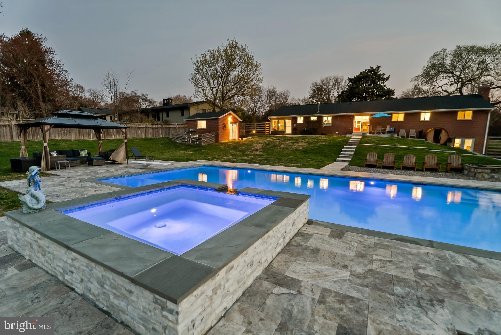 Welcome to a truly exceptional, custom-designed retreat set on 1.1 acres in sought-after Silver Spring. This rare, fully renovated home offers the perfect blend of luxury, privacy, and modern convenience—just minutes from Washington, DC.

The outdoor oasis is nothing short of spectacular. A 20x40 heated gunite saltwater pool and 8-person spa—both app-controlled—serve as the centerpiece, surrounded by elegant travertine decking and walkways. Enjoy a permanent gazebo, custom stone firepit, cedar sauna, retaining walls, and a fully fenced yard designed for both relaxation and entertaining. Newly planted Green Giant Arborvitae, Crepe Myrtles, and Lilac trees enhance the property’s beauty and privacy.

A standout feature is the fully renovated detached brick pool house, perfect as a home office or guest retreat, complete with new windows, architectural shingle roof, updated flooring, exposed vintage wood beams, and a brand-new mini-split system. A cedar outbuilding provides additional storage for pool and outdoor equipment.

Inside, the open-concept main level has been completely reimagined, offering 4 bedrooms and 2.5 baths. Stunning hardwood floors flow throughout the living, dining, and chef’s kitchen, which features all-new appliances and custom cabinetry. Spa-inspired bathrooms with custom tile and rain showerheads elevate everyday living, while a spacious laundry room and sunroom add both function and charm.

The fully finished walk-out lower level offers incredible flexibility, featuring a full kitchen, expansive living space, large bedroom with cedar closet, spa-like full bath, brand-new fireplace, and plush carpeting—ideal for an in-law suite, guest quarters, or multigenerational living.

Every detail has been thoughtfully upgraded in 2024/2025, including a new roof, gutters, HVAC (2023), windows, flooring, paint, driveway, and garage door. A rare turnkey opportunity offering luxury living, resort-style amenities, and unmatched privacy in a prime location.