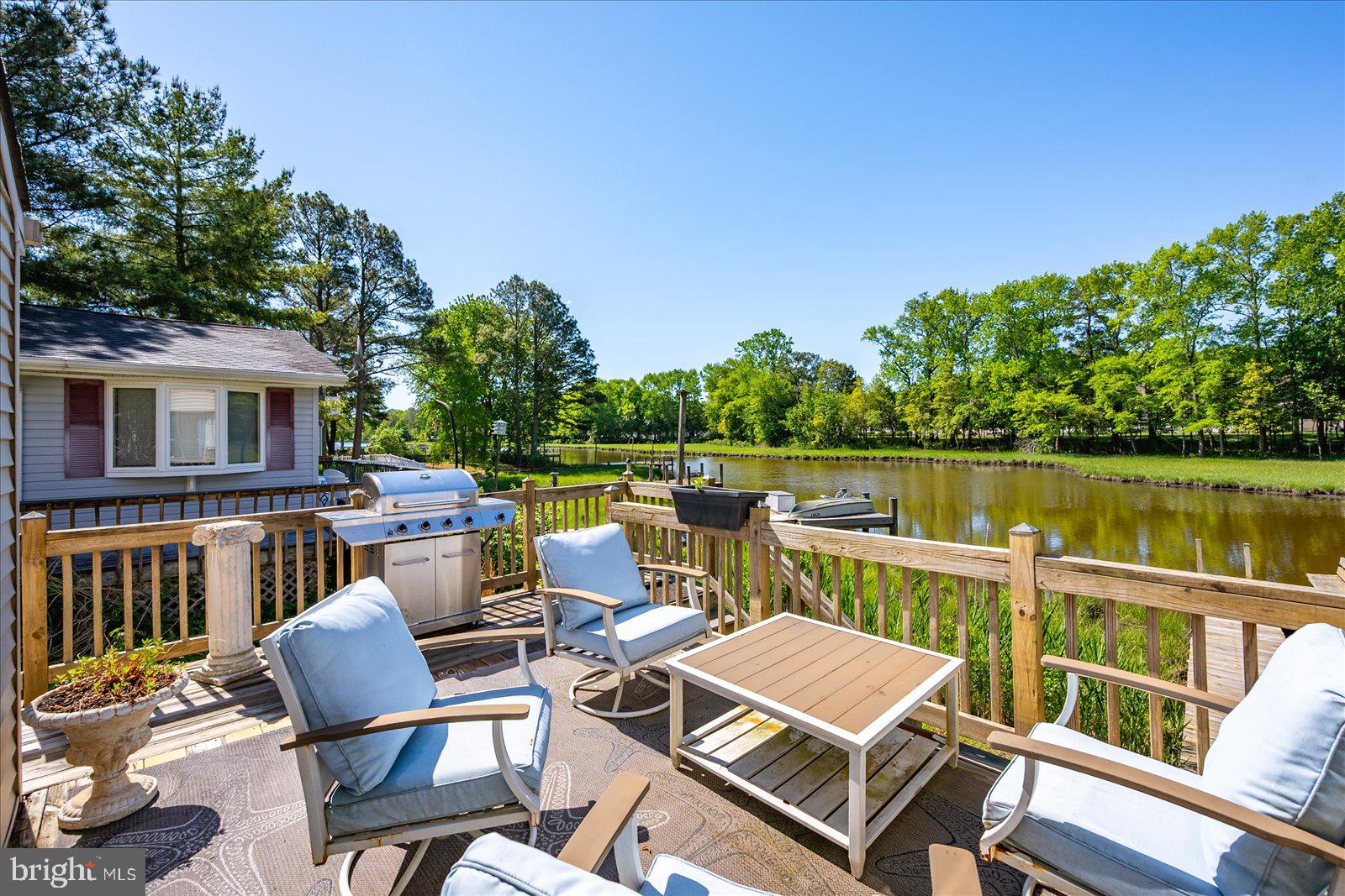 Welcome to this exquisite contemporary waterfront home nestled in the highly desirable community of Ocean Pines. Situated on a serene tidal creek, this stunning property offers a wonderfully private setting with scenic views of the water and  preserved trees that shall remain undisturbed.   Enjoy the charm of this quiet waterway from the deck or numerous rooms.  Inside, the large windows  create a bright and inviting atmosphere throughout. The home has gleaming cherry floors that add warmth and elegance to the open floor plan. The gourmet kitchen is a chef’s dream, featuring stainless steel appliances, quartz countertops, a stylish backsplash, and a spacious island perfect for entertaining. The home also boasts a cozy wood stove, ideal for chilly evenings.  The recent renovations  combine modern updates with tasteful  design. The expansive wraparound deck, offers spectacular views of the water and access to the private pier—perfect for relaxing, kayaking, canoeing and water sports.  Living in Ocean Pines means enjoying a vibrant community with golf courses, a yacht club, parks, walking trails, tennis courts, and pools—offering something for everyone. This beautifully updated waterfront home truly combines luxurious living with the natural beauty of its surroundings.   Schedule your appointment day and make 26 Boston Drive your perfect summer escape!