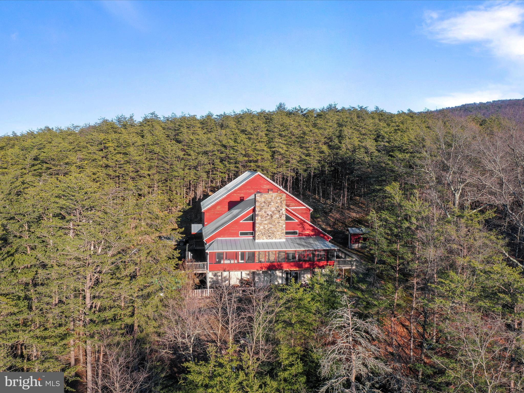 Welcome to your dream mountain retreat—a custom-built, three-story timber frame lodge surrounded by breathtaking scenery and endless outdoor adventure. This extraordinary property offers the perfect blend of rustic charm and modern comfort, with 198.5 acres of pristine land, two ponds, abundant wildlife, and easy access from the main road. From the moment you enter the main floor, you’ll be captivated by the exquisite craftsmanship—beautiful hardwood floors, soaring ceilings, and expansive windows that fill the space with natural light and showcase the panoramic mountain views. The main floor features a spacious primary suite with two walk-in closets and an ensuite bathroom, two additional guest bedrooms, and one hall bathroom. The great room is anchored by a stunning craftsman-style stone fireplace, perfect for cozy evenings. The kitchen with bar seating is designed for gatherings, and just beyond, the panoramic deck—partially covered and screened—provides the perfect spot to enjoy your morning coffee while watching the sunrise. The upper level offers four oversized bedrooms and two full bathrooms, providing ample space for family and guests. On the lower level, you’ll find a large living area, four additional bedrooms, a full bathroom, and tons of storage. This level also includes the utility room and offers direct access to the 1-car garage. The home is heated by efficient in-floor radiant heat, ensuring year-round comfort. With plenty of usable flat land, the property is ideal for outdoor activities, farming, or creating your own private oasis. Two ponds attract local wildlife, making this a paradise for nature lovers, and the property’s proximity to the North River adds even more opportunities for outdoor recreation. As a bonus, the property includes a charming A-frame cabin—a cozy 1-bedroom, 1-bathroom retreat with a loft, located close to the river making it perfect for guests, a rental, or a peaceful escape from the everyday hustle. Lovingly cared for and cherished for generations, this exceptional property is now ready for its next chapter. Whether you’re dreaming of a private family retreat, a homestead, or a recreational haven, this rare offering has it all. Located 20 minutes to Moorefield, WV, Less than 30 to Wardensville & the Lost River Valley, Less than 2 1/2  hours from Washington DC. Schedule your private tour today!