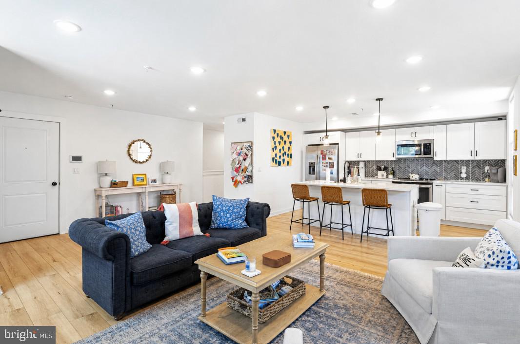 This stunning 2-bedroom, 2.5-bath condo offers modern luxury with multiple years remaining on the tax abatement, all in an unbeatable location between Fishtown and Northern Liberties. Inside, you’ll find 8-foot ceilings and hardwood flooring throughout, creating a bright and polished feel. Enter into a spacious living area perfect for relaxing or entertaining, which flows seamlessly into a sleek, designer kitchen. The kitchen features white quartz countertops, shaker-style cabinetry with abundant storage, a custom tile backsplash, stainless steel appliances, matte black finishes, and a large island with seating. The main level also includes a convenient laundry area with a stackable washer and dryer, along with a stylish half bath. Downstairs, the primary suite is a true retreat, complete with a generous walk-in closet and a beautifully finished en-suite bath featuring custom tile flooring and a large walk-in shower. A second spacious bedroom with ample closet space, along with a full hall bathroom featuring custom tile and a tub/shower combo, completes the lower level. The building offers secure entry and package delivery, adding everyday convenience. Located just steps from public transit including trolley and subway lines with easy access to I-95 and I-676, commuting is a breeze. Plus, you’re within walking distance to all the dining, shopping, parks, and nightlife that Fishtown and Northern Liberties are known for.