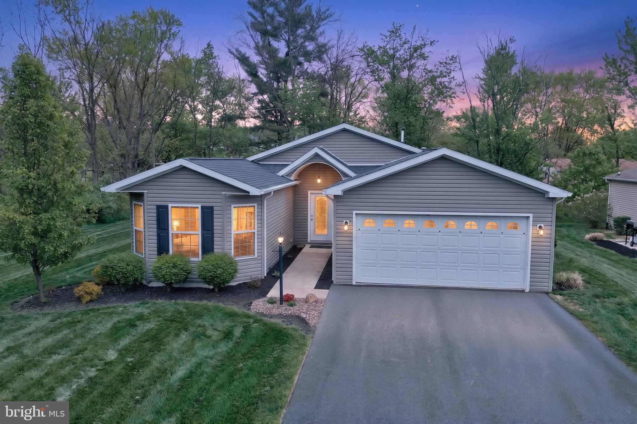 Located in the beautiful 55+ community of Spring Valley Village, at the end of Cormorant Rd., you’ll find this 1,812 sq. ft. Manchester model featuring all of the important upgrades. Bordering a wooded area on two sides, the home offers a private, peaceful setting. The welcoming two-car garage provides ample space, complete with a convenient storage loft. Upon entering the front door, you’re greeted by a spacious tiled foyer that creates an elegant first impression. The garage leads into a functional mudroom off the foyer, featuring a generous closet and housing the home’s utilities. The west wing extends from the foyer and includes a versatile flex room that can serve as a bedroom or office, a full bathroom, and a third bedroom highlighted by three large turret-style windows. The open-concept kitchen, living room, and dining nook are filled with natural light, enhanced by beautiful wood flooring and an ideal layout for entertaining. The kitchen features upgraded white cabinetry, stainless steel appliances, and stunning marble countertops. A raised dishwasher adds convenience and ease of use. The large island offers additional seating, while the adjacent nook provides space for a dining table overlooking the sliding glass doors. The living room showcases a temperature controlled gas fireplace and abundant natural light. Down the east hall, you’ll find a spacious utility room with washer, dryer, and additional storage, as well as the primary suite. The primary bedroom connects to a well appointed bathroom featuring an upgraded tiled shower, double sinks, and a private water closet, along with a generous walk-in closet with shelving. Enjoy your morning coffee on the expansive patio, which easily accommodates both lounging and dining areas. The outdoor space is surrounded by mature, professionally maintained landscaping, and leaf guards on the gutters make seasonal upkeep simple.
Move right in, relax, and enjoy all this home has to offer! An application and application fee of $295.00 is required for Spring Valley Village LLC and is subject to community approval.