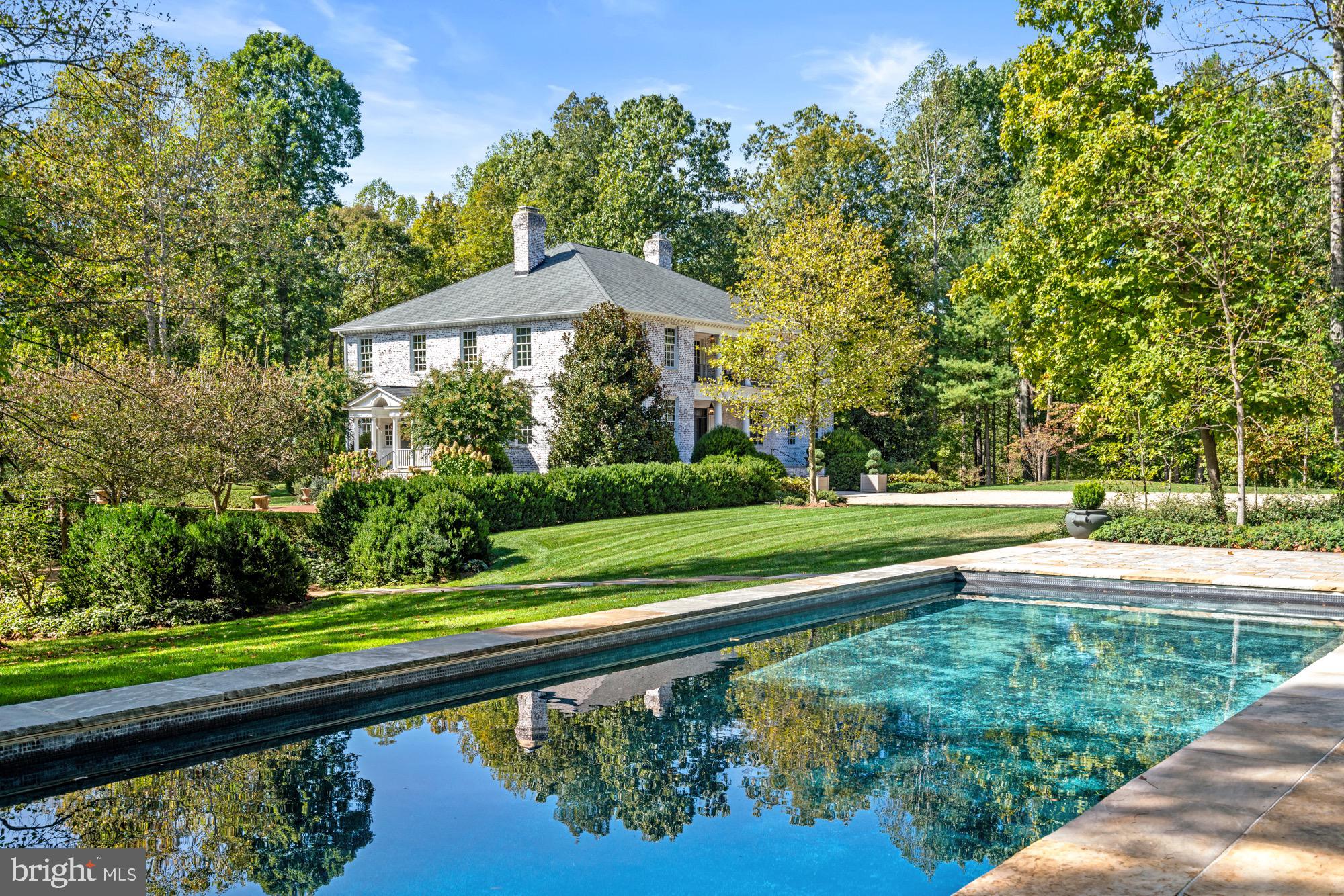 Stoneledge represents the heart and soul of Virginia’s countryside. Unrivaled in its beauty and prime caliber, this Warrenton estate sweeps across more than 100 acres featuring a quarter-mile private drive, pea gravel motor court, stylish pool with entertaining kitchen pavilion and cabana, one bedroom guest house with vaulted ceilings and screened porch, two stall barn, formal gardens, bucolic open pastures, tranquil woodlands and pond. This majestic and meticulously maintained home built in the Georgian style is in a class by itself. It spans nearly 11,000 square feet with 12-foot ceilings highlighted by sophisticated plaster moldings and pilasters in both the oversized living room and dining room. The floor plan across three levels features five bedrooms including a sprawling primary bedroom with separate sitting room. A bespoke kitchen with exposed beams dating back to the 1800’s is nothing short of awe-inspiring which includes a maple wood island, custom barn wood cabinetry and top of the line Viking appliances. The library is designed with ceiling height ponderosa pine book cases and fireplace. A light filled garden room joins the living room and kitchen with direct access to the brick loggia creating effortless flow. The second floor is designed with two large en-suite bedrooms and the private primary bedroom wing. The bathroom suite includes two marble vanities, hidden refrigeration and walk-in closet. The lower level with quarter-sawn white oak floors includes two more bedrooms, full marble bathroom, enclosed wine room and an entertaining space that stretches the entire length of the house featuring a stacked stone fireplace, gym and walk-out glass door to the rear grounds. An elevator services all three floors. The expansive pool and pavilion was designed in 2019 by celebrated landscape architect, Richard Arentz. Additional recent improvements and upgrades since 2022 include the second floor portico, butler’s pantry, all bathrooms, commercial grade wiring with surge protection, Starlink internet and two generators. It’s a rare and almost unheard of combination of quality, design, natural beauty and privacy. Stoneledge is modern country living at the highest level. Available totally turn-key at $5.5M. A full length video featuring exteriors and interiors is uploaded in the listing.