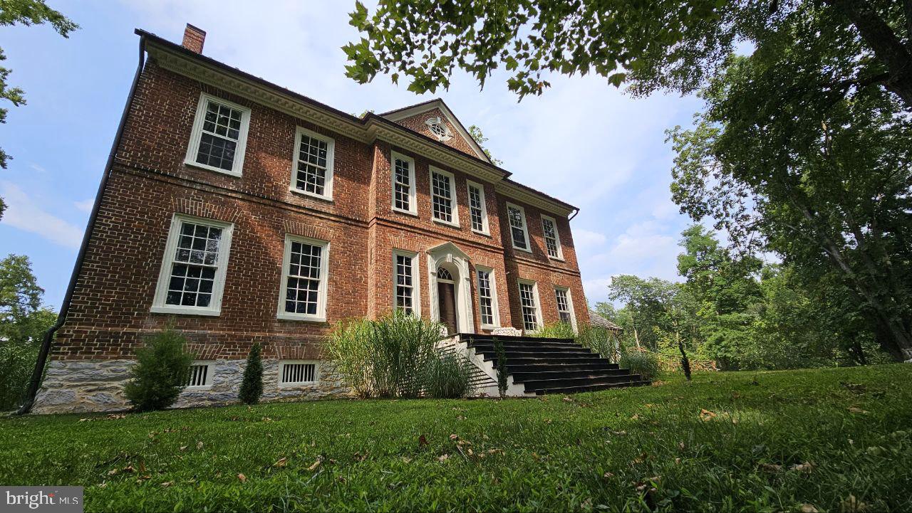 **The Robert Worthington Piedmont House**

***Actively showing and accepting offers***

Documented by historians as the finest example of Georgian architecture in West Virginia, the Piedmont House is a property unlike any other — set on 29 serene acres, a quarter mile back from the road, surrounded by rolling farmland and hills that extend the sense of privacy and natural immersion far beyond the property lines. Just 1.5 miles from downtown Charles Town and 68 miles from Washington, D.C., yet worlds away. Built in 1735 by Royal Crown land grant and expanded in 1785, the estate has passed through a distinguished line of caretakers, among them the late Jim Lehrer of PBS. What they left behind is a home that lives as beautifully as it looks.

Original heart pine floors, period millwork, and a fireplace in every room anchor the interior in its history. The formal sitting room is home to some of the earliest wallpaper in America. The master suite offers a copper soaking tub and fireplace. A custom wine cellar with ebony marble flooring, a third-floor library, and two fully updated kitchens with granite and butcher block countertops. The 1735 limestone wing — with its own kitchen, bath, and private entrance — functions as a self-contained suite, ideal for extended family or guests. Thoughtful infrastructure upgrades throughout include updated HVAC, electrical, and plumbing, as well as a newer heat pump, washer/dryer, and dishwasher.

Outside, the property is fully equipped for the working homestead. Seven mature laying hens and a 30-by-10-foot coop and run are ready to go from day one. A fenced kitchen garden with established herbs and vegetables opens onto land that is genuinely exceptional — limestone-rich, nitrogen-dense soil with the fertility to support large-scale cultivation, livestock, and horses. Evitts Run and the Piedmont-Altona marl marsh define the southeastern acres, and a long-standing conservation relationship ensures this rare habitat is protected in perpetuity.

The outbuildings are extensive: a large barn with cement floor and new roof (December 2025), a detached two-car garage with cement floor, a full-size tennis court, a smokehouse with electricity, and a pump house. A caretaker's cottage from the early 1900s sits at the back of the property — its foundation solid, its potential undiminished — awaiting restoration as a second home.

The ruins of St. George's Chapel (1769) line the driveway — where George and Samuel Washington once worshipped. After Sunday services, the congregation would gather for tea at Piedmont.

From the exquisite French wallpaper to the stone paths throughout the gardens, there is simply too much magic here to capture in words. Come experience it for yourself.