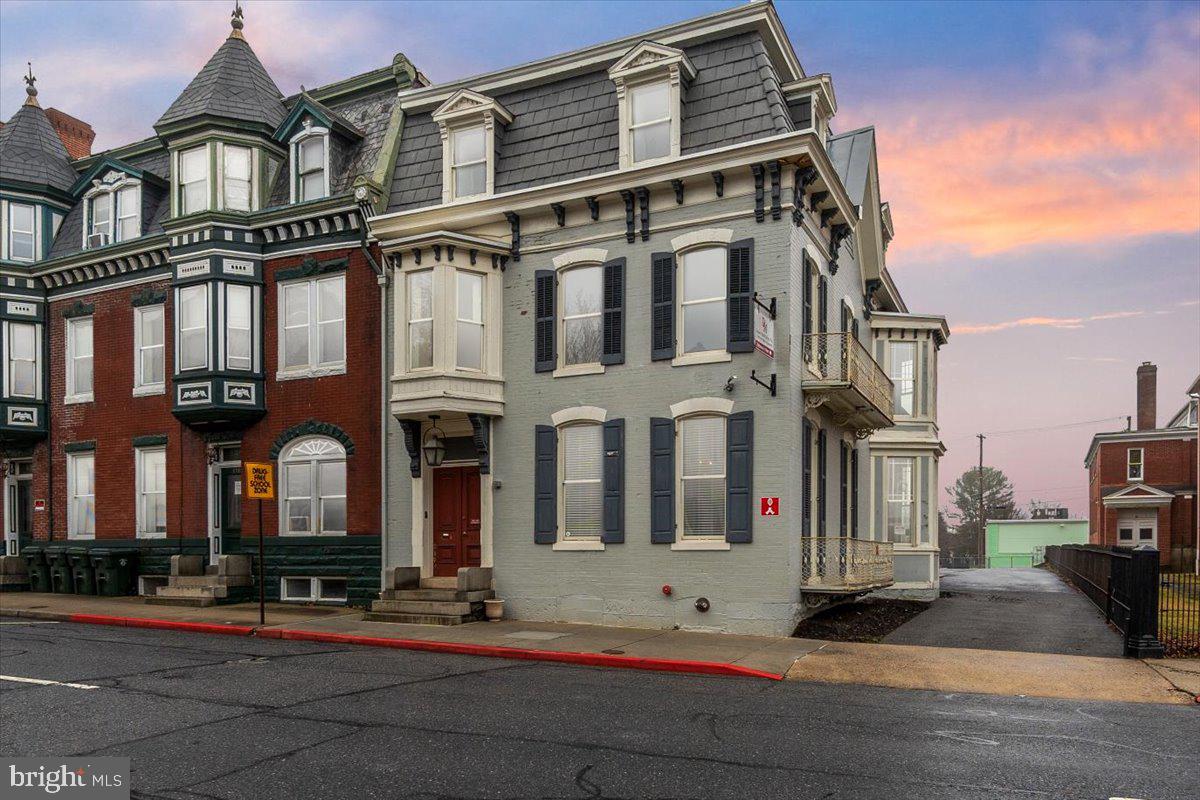 Discover the timeless elegance and exceptional potential of this grand Colonial residence, ideally positioned to capture the best of downtown living. Previously used as an accounting firm/office. Offering an impressive 4,248 square feet, this stately home showcases remarkable architectural character rarely found today — from floor-to-ceiling and bay windows to pocket doors, interior shutters, leaded glass accents, and beautifully detailed ceramic tile. Inside, the gracious living and dining rooms are separated by pocket doors and provide the perfect setting for entertaining, while the upper level features five generously sized bedrooms, offering flexibility for family living, guest accommodations, or home office space. With some updates and personal touches, this property presents a wonderful opportunity to enhance its historic beauty while adding modern comfort and value. Outside, charming sidewalks frame the property and contribute to the neighborhood’s classic appeal. Off-street parking and convenient driveway access make daily living effortless — a true advantage in this sought-after downtown location. Situated in a vibrant community within walking distance of Meritus Park (The Flying Boxcars baseball stadium), local parks, downtown coffee shops and restaurants, schools, and The Maryland Theater, this home offers both character and convenience. Whether you’re looking for historical brilliance or to thoughtfully modernize its interiors, this remarkable residence is ready to become something truly special.  Property is zoned CCMU - buyer to verify residential use.