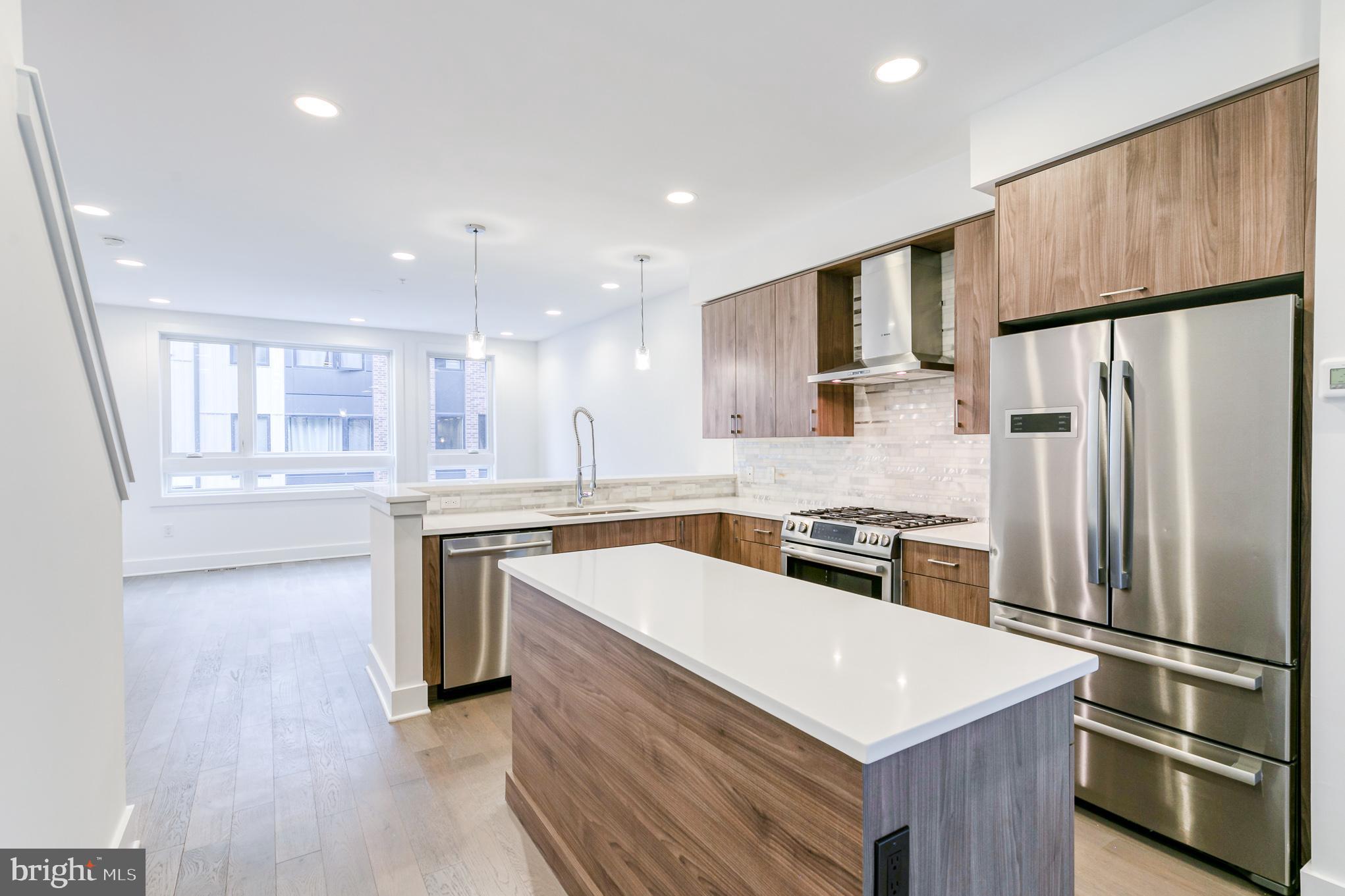 This newer-construction four-story townhouse delivers refined city living with a clean, modern aesthetic, garage parking, and three private outdoor spaces, including two balconies and a stunning rooftop deck with sweeping skyline views. Well maintained and thoughtfully designed, the home offers 3 bedrooms, 3.5 bathrooms, and hardwood floors throughout, all tucked into a quiet courtyard just off the vibrant 5th Street corridor in Northern Liberties.
A welcoming entry level features a spacious foyer with powder room, full laundry area, mechanicals, and direct access to the attached one-car garage with impressive additional storage. 
The second floor is ideal for entertaining, showcasing a bright open layout with a chef’s kitchen appointed with marble countertops, stainless steel appliances, custom cabinetry, and a breakfast bar. A formal dining area flows seamlessly into the living space, where southern exposure and oversized windows fill the home with natural light. Step directly onto a private balcony for effortless indoor-outdoor living.
The third level offers two generously sized bedrooms, including one with an en-suite bath, along with a beautifully finished full hall bathroom featuring marble finishes and modern fixtures. 
The top floor is reserved for the primary suite retreat, complete with a private balcony, expansive walk-in closet, double vanity, and a spa-inspired glass-enclosed shower.
Crowning the home is a large rooftop deck—an ideal setting for entertaining or unwinding—boasting unobstructed views of the Philadelphia skyline. Located just steps from Amazon Fresh, Target, Liberty Lands Park, Café La Maude, Standard Tap, public transportation, and the best of Northern Liberties dining and shopping, this home seamlessly blends style, comfort, and convenience.  Photos may depict a similar unit.