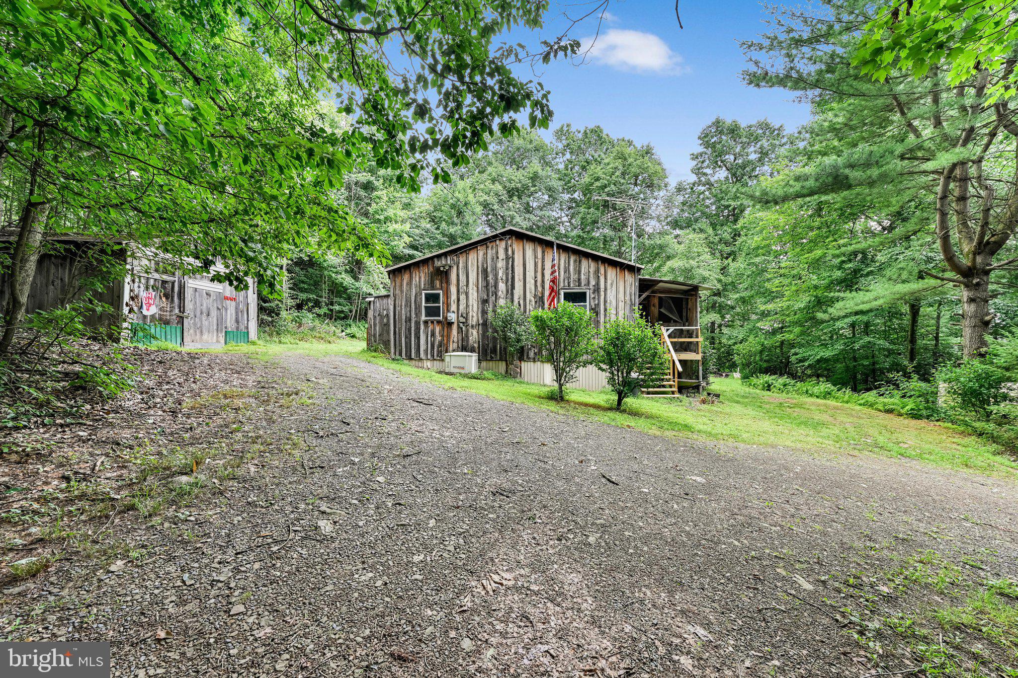 Cozy one-floor living cabin on a 5-acre, partly secluded wooded lot on Lighthouse Lane, with access to state game land. 2 screened-in porches that open to the home. There are 2 bedrooms, 1 full bath, an open living, dining, and kitchen area with all appliances to remain. 200-amp service, propane-heated, Generac-powered, outbuildings, and a wraparound driveway for easy access and plenty of parking.