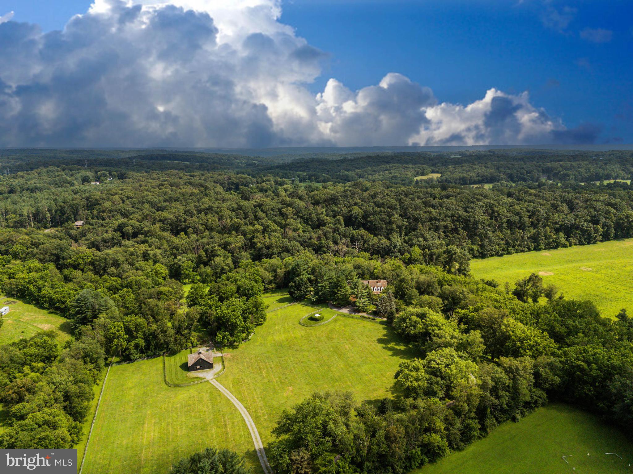 Live authentically. Stones Throw Farm. Set in the heart of Greenspring Hunt Country, this exceptional 18.01 acre estate offers unrivaled privacy amid gently rolling pastures. A meandering tree-lined drive heightens your sense of arrival, as sweeping panoramic views unfold all around. The landscape is embraced by a meandering stream on three sides with walking trails... quite remarkable. The plantings are masterfully composed, framing epic sunrises and sunsets. The home’s architecture balances rustic authenticity with refined comfort. A first-floor primary suite with spa bath features premium views of your beloved animals in the pasture beyond. The expansive cooking space invites convivial gatherings, opening seamlessly to a generous deck and patio designed for effortless entertaining. A state-of-the-art equestrian barn over-engineered where supreme functionality meets beauty. Bespoke chicken coop redefines pastoral indulgence. Here, the rhythms of nature shape daily life—birdsong at dawn, open skies at dusk, and the abiding calm of land and water in perfect harmony. Stargazers rejoice... your very own celestial observatory. Take photos and ponder the cosmos. Xfinity Internet. Cultivate your existence. The art of uniting human and home.