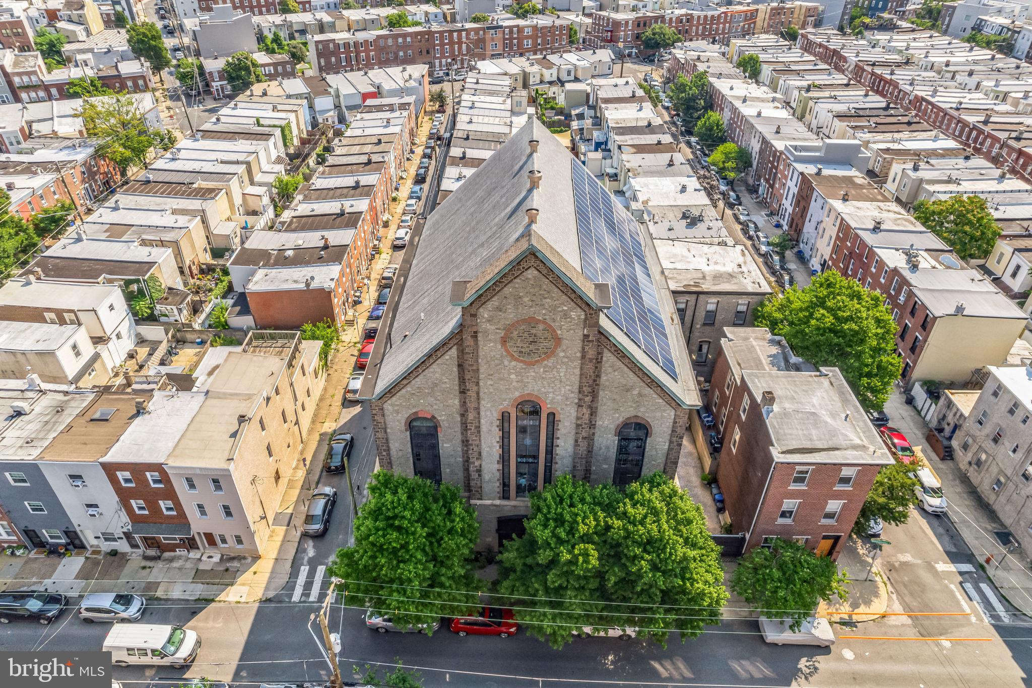 Step into a piece of Philadelphia history—this iconic stone church-turned-multifamily property in the heart of Fishtown is bursting with character, opportunity, and smart updates. Built between 1845–1860, this soaring 60-foot structure originally housed the Siloam Methodist Church with modern upgrades, making it a truly unique opportunity for multifamily living, creative workspaces, or income-generating rentals.

With 128 panels producing between 34,000 and 36,000 kilowatt-hours annually, the system covers the majority of the building’s electric usage. It includes four inverters located in the full 3,500-square-foot basement, which also offers 10-foot ceilings, a kitchenette, two bathrooms, and extensive storage. Major renovations are already complete, including a brand-new roof added in 2023 and new downspouts installed in 2022.

The exterior offers privacy and convenience with an 8-foot white cedar fence, a beautiful stamped concrete courtyard, and a 22-foot electric door with space to park 2–3 vehicles. Inside, you're greeted by grand mahogany staircases and incredible architectural details throughout. The first-floor studio is a wide-open loft space with a kitchen, lounge, makeup area, and full bathroom—recently rented at $1,400 per day as a photography studio. Just above, the awe-inspiring sanctuary has 35-foot ceilings and stained glass windows.  This room is a blank canvas to let your imagination and designer inner-child go wild.

The third floor serves as the owner’s unit, blending old-world charm with custom design. It features salvaged doors, a stunning bathroom with heated floors and stained glass shower, two large bedrooms, and a stunning custom dressing room. 

Two additional loft-style apartments offer private entrances, large kitchens, bathrooms, separate electric and gas meters, and shared laundry. They will be delivered vacant. Rents range from $2,000 and $2,500 per month, giving you immediate rental income.

Comfort is ensured year-round with six HVAC units heating and cooling each area of the building individually. Best of all, the location is unbeatable—just steps from neighborhood favorites like Bastia in Anna & Bel, Suraya, LMNO, Green Eggs Café, La Colombe, Kalaya, Riverwards Produce, and more. With quick access to I-95, Center City, New Jersey, and NYC, and located in The Adaire School catchment.