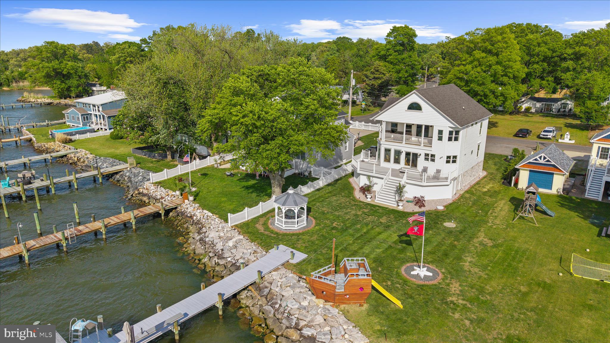 Exceptional waterfront home sitting at the mouth of Rock Creek with wide open bay views and front row seats to some of the best waterfront living Pasadena has to offer. Tucked away at the very end of Fort Smallwood Road, this home offers a rare combination of privacy, open water views, and easy access to life on the bay.

Designed for true waterfront living, the private pier features 3 boat lifts plus a jet ski lift, approximately 5’ MLW, multiple waterfront decks, a waterslide, and an outdoor shower for long summer days spent outside. Launch a kayak or paddleboard to the famous Rock Creek cliffs and nearby sandbars, or hop on the boat and quickly access some of the Bay’s favorite waterfront restaurants and destinations.

Inside, the home was extensively remodeled in 2020 and thoughtfully designed to maximize both functionality and views. Custom hardwood floors with inlays, Thermador appliances, hidden storage, under-stair closets, and walls of windows combine quality craftsmanship with comfortable everyday living. Nearly every room captures incredible water views across the bay toward the Baltimore skyline.

The primary suite feels like its own private waterfront retreat, and beneath the home you’ll find over 1,400 square feet of additional storage space ideal for boating gear, hobbies, workshop space, and everything that comes with waterfront living.

Residents enjoy access to a private community beach, park, neighborhood events, and Fort Smallwood Park just a short walk away. Evening showings are highly encouraged to fully experience the sunsets and waterfront setting.
