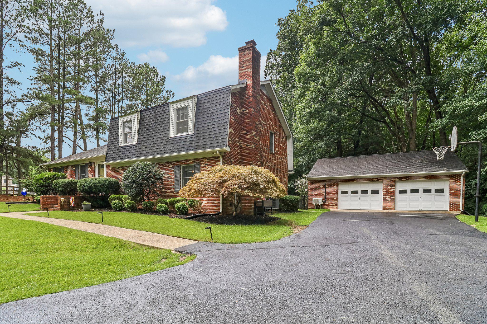 Nestled on a private 4.26-acre wooded homesite in Brynwood Farm Estates, this well-maintained brick split-level offers peaceful Southern Maryland living with everyday convenience. Hidden in a forested valley with natural beauty all around, the home combines Dutch Colonial-inspired exterior character with a classic mid-century tri-level layout. Solid construction, real hardwood floors, brick accents, a wood pellet burning fireplace, generous windows, and thoughtful upkeep give the home the warmth and personality buyers often miss in newer builds. The main level includes an entryway foyer with two coat closets, living room, dining room with a fantastic picture window, and a kitchen with access to the screened porch. The lower level includes a family room, laundry/utility/mud room, and a private bedroom suite with a connecting full bath—ideal for guests, multigenerational living, a teen suite, office, hobby space, or second primary suite. Upstairs, the primary suite offers its own connecting full bath, along with two additional bedrooms and another full bath. The traditional three-level layout creates natural separation between living, sleeping, work, and guest spaces, while keeping the home connected and comfortable. Significant updates offer peace of mind, including a sealed crawlspace with commercial-grade dehumidification system (2022) and a 450 foot well (2018). Another of the home’s valuable improvements is the 2025 Carrier 16 SEER high-efficiency heat pump, supporting year-round comfort with modern electric heating and cooling. The home also retains its oil-fired baseboard heat, giving the flexibility of two heating options rather than relying on a single system. Additional interior features include quartz countertops, a kitchen island with butcher block top, central vacuum, hardwood and tile flooring, and a fireplace with a pellet insert. A true standout feature is the oversized climate-controlled detached two-car garage, complete with a wood burning fireplace and mini-split HVAC system (2025). More than basic parking, this space offers serious year-round workshop potential and ample storage—ideal for hobbyists, woodworkers, mechanics, gardeners, gear storage, or outdoor enthusiasts. Outside, the property delivers the acreage buyers dream of: a large screened-in porch that leads to a patio area, a backyard fire pit, flat fenced-in backyard with garden beds, front yard play area, wooded trails, mature trees, and frequent visits from deer, owls, hummingbirds, and lightening bugs. The screened porch extends the living space outdoors while keeping you comfortably sheltered, and the wooded setting makes nature feel like part of the home. The acreage has a year round flowing creek and shows signs of regular deer movement, including trails, bedding areas, and is a natural funnel area during the fall months for mature whitetail bucks to cruise through - adding to the appeal for wildlife watchers and outdoor enthusiasts. This property offers privacy, no HOA, a welcoming neighborhood atmosphere, and room to spread out while remaining close to town. Enjoy the feeling of being tucked away in the woods while staying within reach of La Plata, Waldorf, commuter routes, military bases, shopping, restaurants, and everyday services. This is Southern Maryland living at its best: privacy, character, useful space, and nature all around.