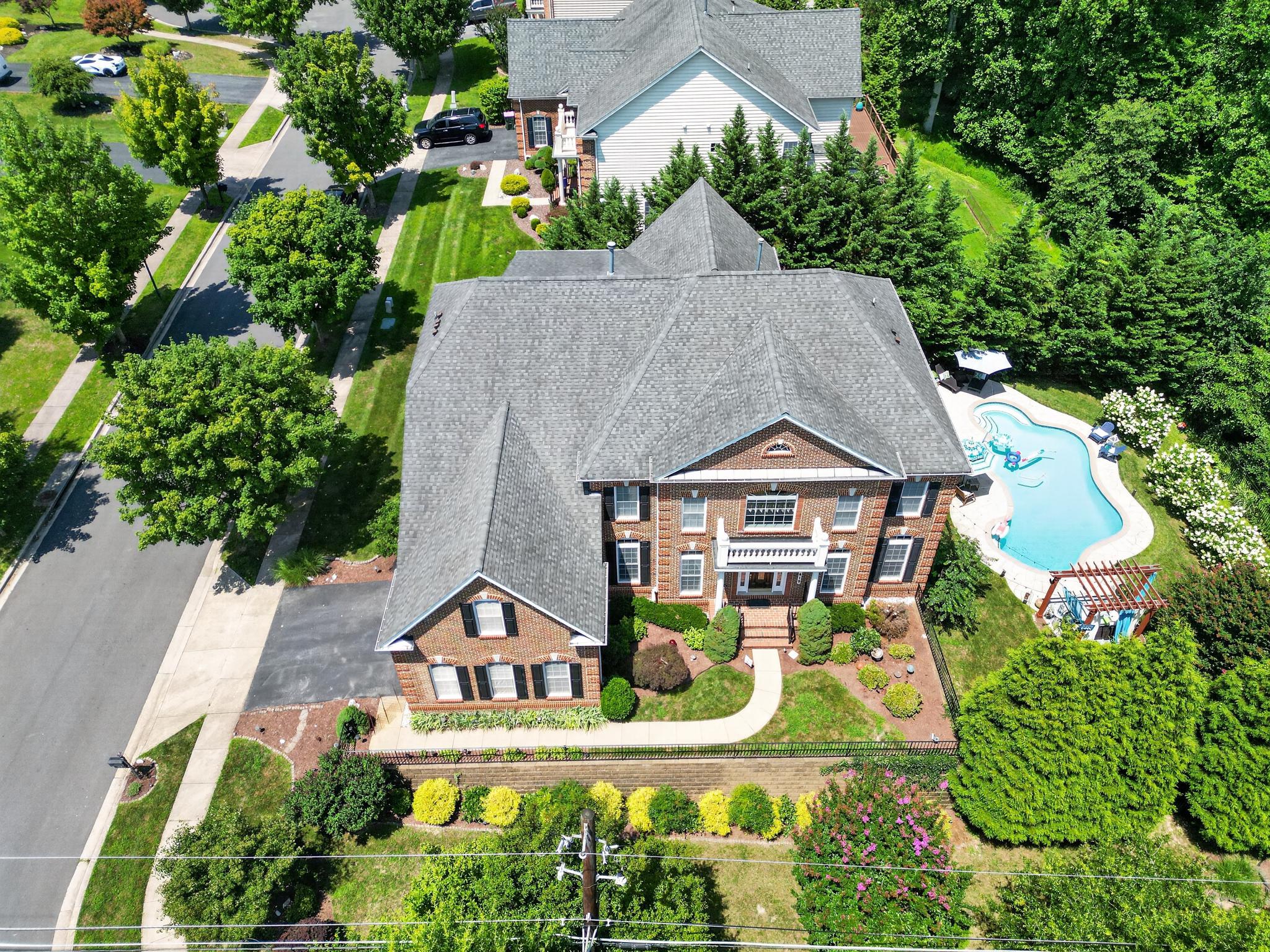This exquisite Colonial home, built in 2007, offers a harmonious blend of luxury and comfort. With five spacious bedrooms and five and a half elegantly appointed bathrooms, this residence is designed for both relaxation and entertaining. Step inside to discover a grand foyer that welcomes you with a stunning curved staircase, leading to an open floor plan that seamlessly connects the living spaces. The family room, adorned with rich hardwood floors and recessed lighting, flows effortlessly into the gourmet kitchen, making it the perfect setting for gatherings. The kitchen is a chef's dream, featuring a double oven, built-in microwave, cooktop, and a butler's pantry, ensuring that every culinary endeavor is met with ease and sophistication. An inviting eat-in area with access to a wrap around deck overlooking the beautifully landscaped yard, creating a serene backdrop for casual dining. Retreat to the luxurious primary suite, complete with a spacious walk-in closet and a spa-like bathroom featuring a jetted tub, perfect for unwinding after a long day. Each additional bedroom is generously sized, offering ample closet space and easy access to well-appointed bathrooms. The fully finished walkout basement adds an extra layer of versatility to this home, providing additional living space that can be tailored to your needs-whether it be a home theater, gym, or guest suite. Natural light pours in through the windows, creating a warm and inviting atmosphere. Outside, the corner lot boasts a beautifully manicured yard, complete with a personal in-ground pool, perfect for summer relaxation and entertaining. The expansive deck and patio areas invite you to enjoy al fresco dining or simply bask in the sun, surrounded by lush landscaping. Additional features include a side-entry attached garage with ample parking on a paved driveway, ensuring convenience and ease of access. The home is equipped with modern amenities, including a laundry room conveniently located on the main floor, making daily chores a breeze. This property is not just a home; it's a lifestyle. Experience the perfect blend of elegance and comfort in a community that offers tranquility and accessibility. Embrace the opportunity to make this luxurious residence your own, where every detail has been thoughtfully curated for your enjoyment.