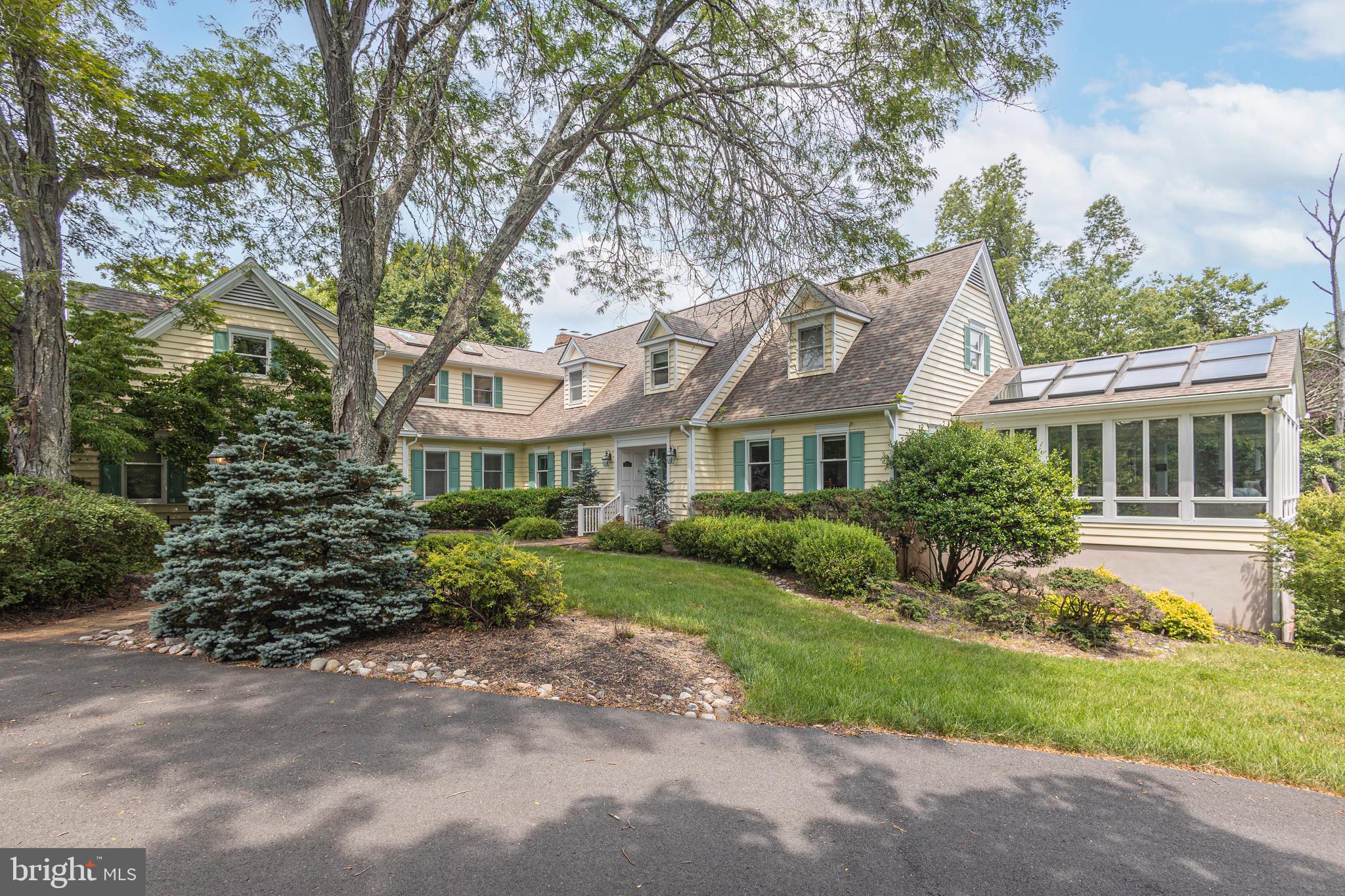 A charming, expanded Cape Cod nestled on just over 3 acres of meticulously landscaped grounds just minutes from historic Washington Crossing State Park. This residence seamlessly blends elegance, comfort and oneness of nature. From custom millwork and wide-planked oak floors to the expansive, light-filled sunroom; every detail has been thoughtfully designed and executed. The heart of the home is a spacious kitchen that flows into a spacious family room with a wood-burning fireplace. Entertaining effortlessly with a home theater and walkout lower level with full custom-built 3-tap 12-seat bar complete with a temperature-controlled wine cellar, game room, office, workout room and whatever else you can imagine. Upstairs you will find 4 bedrooms each with ensuite bath offering ample space for family and guests including a bonus private au pair/guest suite on the main level. The primary suite is a true sanctuary, featuring a cozy fireplace, private deck, and spacious bath. Beyond the interior, discover outdoor living at its finest: multiple decks, a paver patio, and a fire pit overlooking the lush landscape and serene creek. A temperature-controlled 7-car garage and a lawn irrigation system complement the outdoor space. We invite you to experience this exceptional property. Schedule your private tour today.