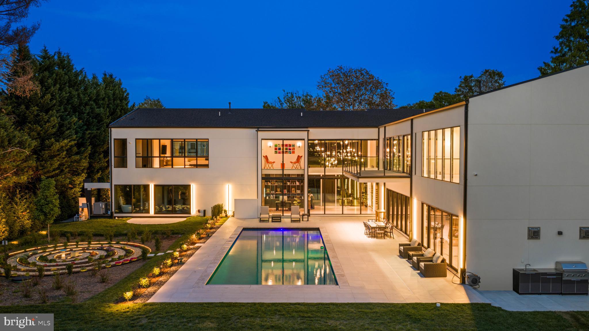 A striking expression of modern luxury, this newly built 2024 custom estate is prominently sited on a rare, 1.13-acre walkout lot in one of McLean’s most desirable settings. Encompassing approximately 12,800 square feet across three finished levels, the residence seamlessly blends bold architectural design with refined, livable elegance.

The main level is anchored by 11-foot ceilings, a two-story foyer, and a dramatic two-story geometric feature wall in the family room - an unforgettable focal point that sets this home apart. Designed for both grand entertaining and everyday living, the expansive layout includes a show-stopping chef’s kitchen with Miele appliances, dual islands, a walk-in pantry, and a fully equipped catering kitchen. Walls of glass frame serene views of the zen garden and tranquil waterfall feature, creating a seamless indoor-outdoor connection. A luxurious main-level primary suite offers ultimate convenience and privacy.

Upstairs, four generously proportioned bedroom suites provide exceptional comfort, complemented by a second laundry room. An elevator services all levels for effortless accessibility.

The walkout lower level is a destination unto itself, curated for recreation and wellness. Highlights include a large recreation room with cocktail bar and integrated LED screen with in-ceiling speakers; a state-of-the-art spa retreat featuring wet and dry saunas, jetted hot tub, and full bath; a private theater, wine cellar, fitness room, additional bedroom suite, and direct access to the rear grounds.

Outdoor living is equally impressive, with a resort-style swimming pool, outdoor kitchen, and expansive terraces overlooking the perfectly level lawn - ideal for entertaining or play. A gated motor court and side-loading four-car garage complete the offering.

Featuring 6 bedrooms, 7 full baths, and 2 half baths, this extraordinary residence delivers a rare combination of scale, design, and amenities - crafted for those seeking a truly elevated lifestyle in McLean.