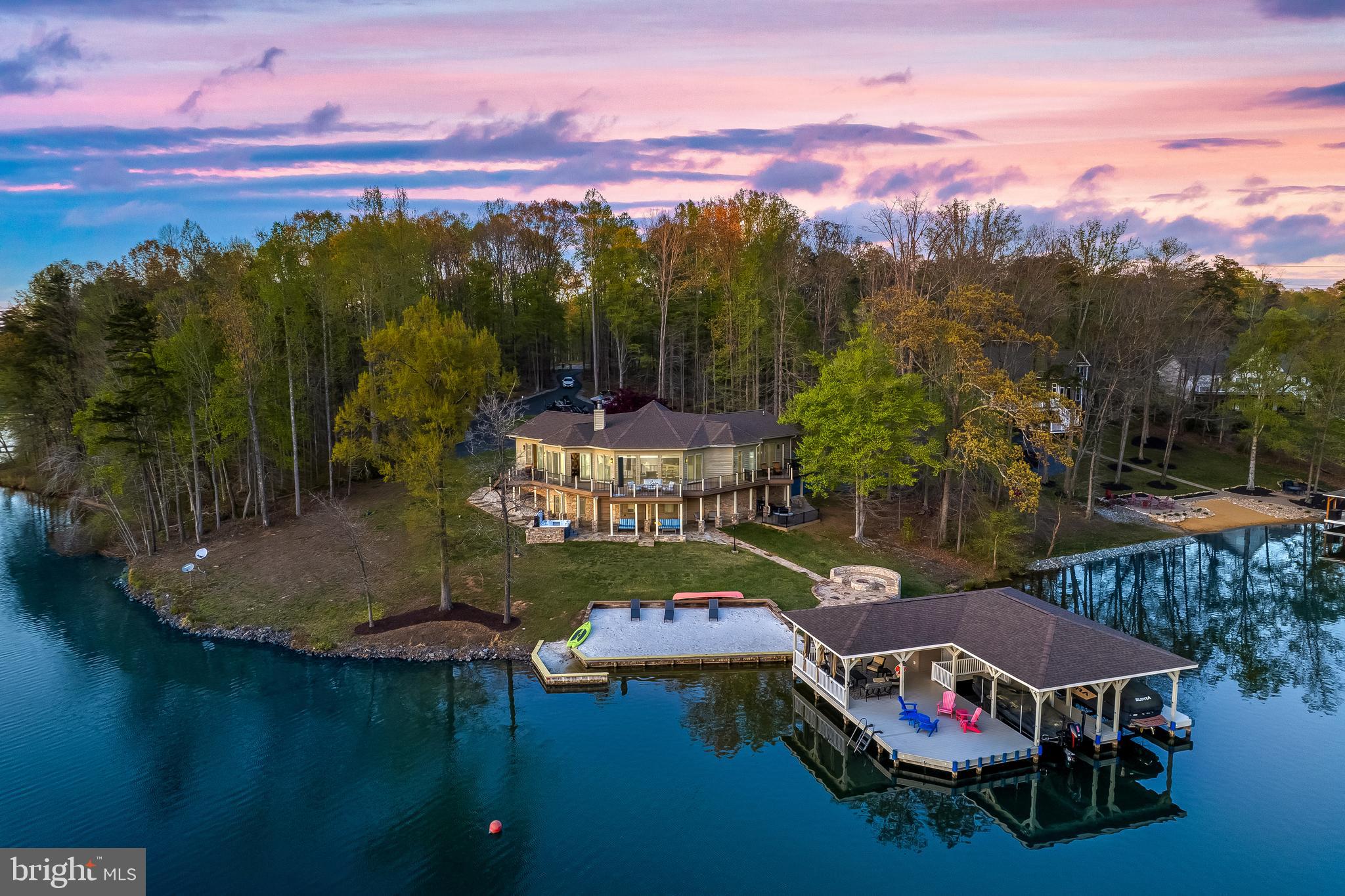 This timeless waterfront beauty spans 4880 sq. ft. and presents a fantastic opportunity for short-term rentals. Featuring an open floor plan, this contemporary home offers both luxury and functionality.

Inside, you’ll find six spacious bedrooms, one den, three full bathrooms, and two powder rooms. Expansive sliding doors lead to a wraparound lakeside deck from every room, offering breathtaking views of Lake Anna. The dining room and family room boast soaring 15-ft ceilings and a double-sided stone fireplace that opens onto a sundeck.

The open-concept kitchen, living, and dining area is designed for both entertaining and everyday living, with 15-ft high ceilings that create a spacious and airy feel. The gourmet kitchen is a chef’s dream, featuring a center island with a built-in farmhouse sink, additional seating, and luxurious countertops. High-end appliances include a Sub-Zero refrigerator and a Viking cooktop. A cozy breakfast nook provides the perfect spot for casual meals. Ample storage space and a walk-in pantry complete this impressive and functional kitchen.

The luxurious master suite overlooks the lake, offering a private retreat where every detail has been meticulously considered. The primary bedroom is bright and airy, with 15-ft high ceilings, a skylight, generous built-ins, and a spacious closet. The master bath features double sinks and an oversized shower.

Every room in this home is spacious and designed to feel like a private suite, creating a comfortable and inviting retreat.

The expansive lower-level walkout offers incredible recreation space, including three bedrooms, one den, a full bathroom, and a powder room. Additional highlights include a large family room with built-in shelves and a recreational area.

Step outside to 250 feet of bulkheaded waterfront, complete with your own private sandy beach, a stone patio with a fire pit, and a covered boathouse. The boathouse features two slips with electric lifts, a storage room, a tiki bar, a sundeck, and a jet ski pad. Additional outdoor amenities include an outdoor shower, a spacious composite deck, and a paved driveway leading to an expansive patio—perfect for enjoying Lake Anna’s natural beauty.

With deep water, panoramic views, riprap shoreline protection, a boathouse, and a deck, this property is a haven for water enthusiasts. The fire pit enhances the outdoor living experience, making every evening by the lake unforgettable.

From sunrise to sunset, the beauty of Lake Anna surrounds you, creating a true retreat.

This is an incredible opportunity to own a move-in-ready custom home on Lake Anna. Schedule your private showing today! The home includes numerous major upgrades. Please get in touch with the listing agent for a complete list.”

With so many delightful features, this dream home won’t last long!

📍 Located in the Cuckoo’s Nest subdivision on the private side of Lake Anna. Don’t miss out!