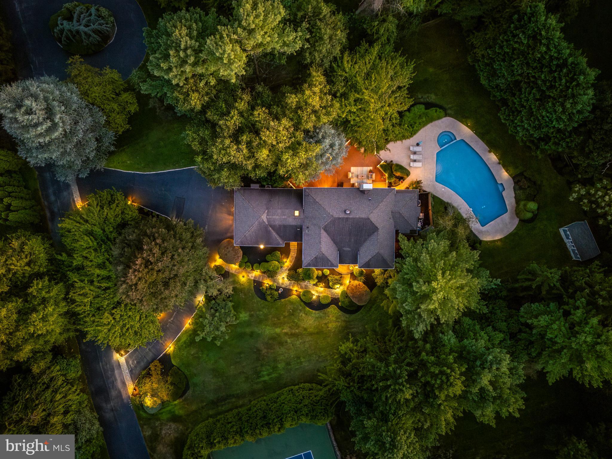 Welcome to 1429 Flat Rock Road, a thoughtfully updated French Colonial estate offering over 4200 sq/ft of comfortable, elegant living space. This private estate nestled on close to an acre of lush grounds with mature landscaping makes a wonderful first impression as you make your way up the semi-circular drive and enter through the double doors into the 2-story foyer with curved staircase and an abundance of natural light. The formal living room features hardwood floors & recessed lighting that continue throughout this lovely home, and a wet bar accessible from the family room as well. Across the foyer is the formal dining room with crown molding, chair rails, and elegant chandelier, providing a sophisticated space to host dinner parties. The remodeled eat-in Kitchen boasts stylish two-tone cabinetry, tile backsplash, quartz countertops, center island with gas range, stainless steel appliances, and a dining area with sliding doors leading to the back deck, making for easy entertaining in the warmer months. Step down into the adjoining family room with built-in shelving, fireplace w/seating, two doors leading to the extensive deck, and plenty of space to gather. An adjoining office with outside access and a full bath w/glass shower & vanity could easily be converted back to a fifth bedroom, au pair or in-law suite. A second front entrance hall with coat closets, half bath, and newly added laundry room complete the first level. Head upstairs to the primary bedroom ensuite featuring a dressing room, walk-in closets, and a full bath with soaking tub, glass shower, double vanity w/storage, and a juliet balcony overlooking the back yard. A second bedroom with full bath ensuite, 2 additional bedrooms, a full hall bath with shower/tub combo complete the second level. The fully finished partial basement featuring built-in cabinetry offers additional living space perfect for a media/game room. The tranquil back yard is your own private oasis, offering a serene setting to start and end your days with your beverage of choice. Relax and entertain on the deck and enjoy time by the pool with family and friends. Perfectly situated in the award-winning Lower Merion School district with easy access to major shopping, restaurants, parks, and all that Penn Valley has to offer. Don't miss out on this incredible opportunity to live in this truly magnificent home!