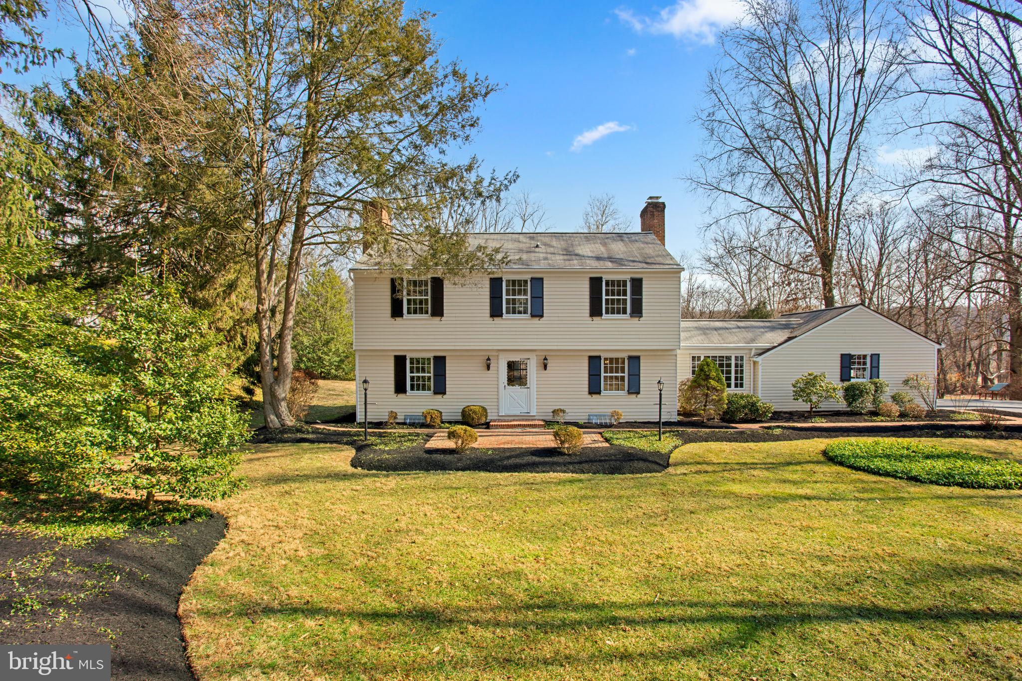 Charming Colonial residence offering 4,300 total square feet, 4 bedrooms, 2 full baths, and 1 half bath set on a beautiful 1.37-acre lot in tranquil Ravenhurst. A long private tree-lined driveway leads to the home, where gorgeous front landscaping and meandering brick pathways create a picturesque first impression. Inside, hardwood floors flow throughout the inviting foyer and into the spacious open living room, featuring a wood-burning fireplace that adds warmth and charm. The formal dining room, adorned with elegant wainscoting and a timeless chandelier, provides the perfect setting for gatherings. The bright and inviting eat-in kitchen boasts ample cabinetry and counter space, complemented by a cozy breakfast nook with a character-filled painted brick accent wall. The expansive family room is a standout space, featuring a wood-burning fireplace framed by gray brick, a wall of built-ins for added charm, and French doors leading to the outdoors. A powder room with all new finishes completes this level. Upstairs, four generously sized bedrooms all feature hardwood floors, including the primary suite with an attached bath. Recent updates include a newly tiled shower with shower niche and reglazed tub, new custom vanity, updated mirror and lighting in the primary bath, and modern upgrades to the hall bath, such as LVP flooring, fresh paint, new mirror and light fixture. Additionally, all toilets in the home have been replaced for modern efficiency. The lower level offers a versatile workshop and ample storage space, with walk-up exterior access for added convenience. Outdoor living is exceptional, with a sprawling deck that overlooks a huge, flat backyard that backs to mature trees—creating a peaceful and private retreat.