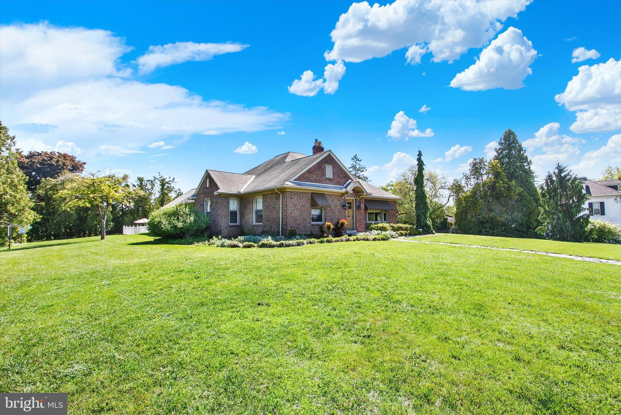 Expansive 2,816 sq ft brick rancher on 1.45 peaceful acre lot sits conveniently near shopping, restaurants, YMCA and more.  Front door leads into the notably large living room with vaulted ceilings with exposed beams, wood flooring and stone wood-burning fireplace.  Continue into formal dining room and eat-in kitchen with double island.  Kitchen has a side entry leading to the flagstone patio.  Celebrate the Nation's 250th Birthday with family and friends in the family room that leads to your own private salt-water pool!   No need to worry about parking for this event with 4 garages and more spaces in the driveway!  3 nice size bedrooms all with wood floors and 3 full bathrooms and additional recreation room on the upper level.  Don't miss the opportunity to make this home yours!  Schedule your showing now.