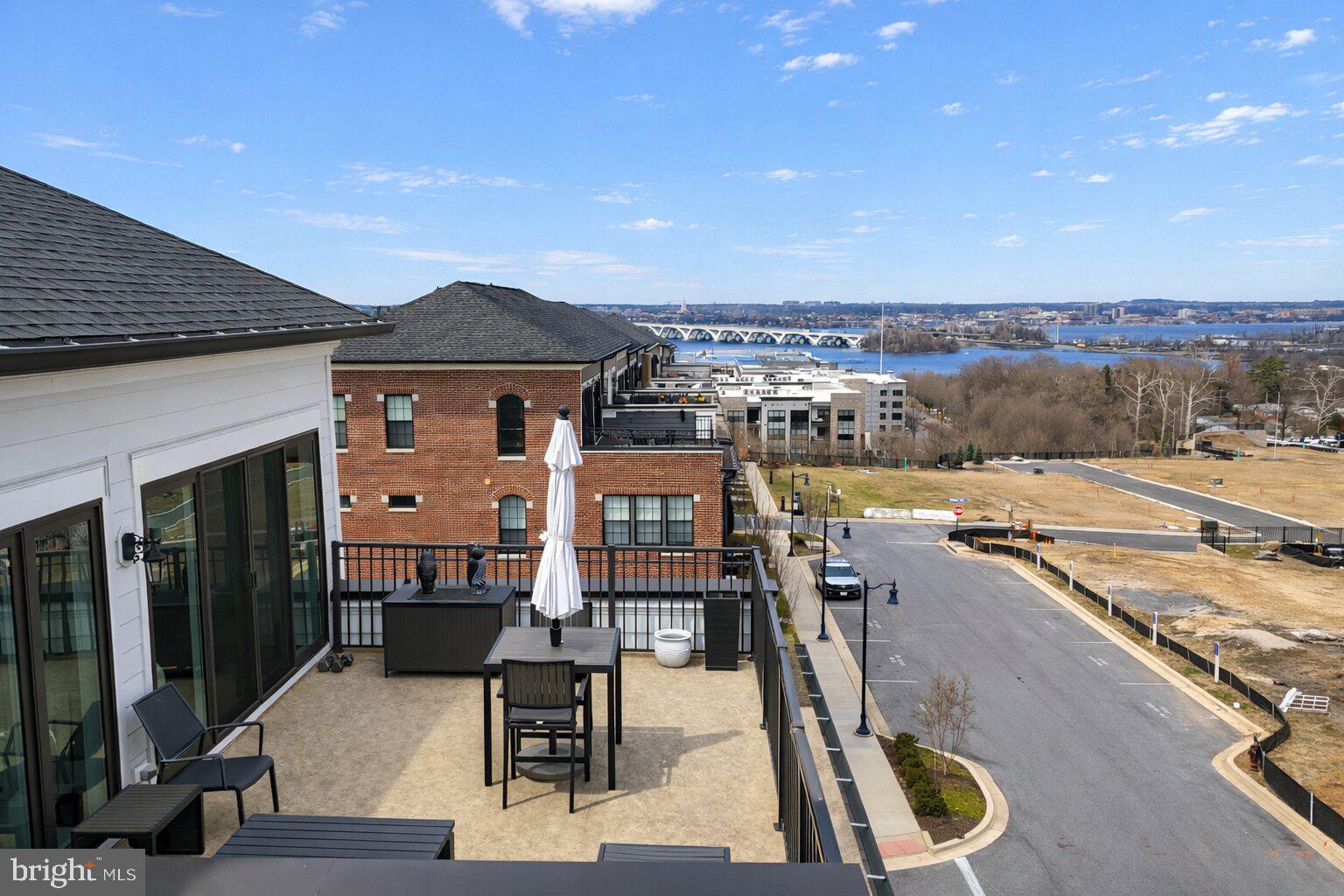 From its gourmet kitchen to its spa-inspired en suite, this home is poised to steal your heart.

Some homes simply look beautiful in photos. Others create a feeling the moment you step inside—a sense of calm, light, and possibility that makes you instantly imagine your life unfolding there. This remarkable corner residence in Potomac Overlook at National Harbor is one of those rare homes.

Built in 2023, this four-level contemporary brick residence is designed to feel open, bright, and effortlessly comfortable, with thoughtfully designed living spaces throughout. Being a corner unit makes all the difference. Extra windows wrap the home in sunlight from morning to evening, filling each level with warmth and creating the kind of natural light that instantly lifts the mood of every room.

Step inside and the experience begins with beautiful light gray wood flooring, recessed lighting, and clean architectural lines that give the entire home a fresh, modern feel.

At the heart of it all is the stunning white gourmet kitchen—a space that feels both elegant and welcoming. Crisp cabinetry, striking marble countertops, a large center island, and premium stainless appliances create a kitchen that is as functional as it is beautiful. The kitchen opens seamlessly to the dining and living areas, allowing the entire main level to feel open and vibrant.

The living room is equally inviting, anchored by a sleek gas fireplace and surrounded by windows that bring the outside in.

Across its four thoughtfully designed levels, the home offers three spacious bedrooms and three-and-a-half baths. Each bedroom feels private and comfortable, with generous proportions and abundant natural light. The primary suite is especially impressive, offering the feeling of a true retreat.

The primary bathroom, inspired by the model-home design, feels more like a spa than a typical bath. Clean lines, elegant finishes, a soaking tub, and a large glass shower create a calming space where everyday routines feel elevated. A custom walk-in closet completes the suite with thoughtful organization and plenty of room for everything.

Additional living space throughout the home offers flexibility for work, hobbies, media, or relaxation.

From the elevated outdoor spaces and expansive windows, the scenery unfolds in a way that feels almost cinematic. The skyline of Washington, D.C., the graceful span of the Woodrow Wilson Bridge, the vibrant lights of MGM National Harbor, and the iconic Capital Wheel create a backdrop that changes beautifully from sunrise to evening glow.

Life here also means being surrounded by the energy of National Harbor—a destination known for its waterfront experiences, dining, entertainment, and vibrant atmosphere along the Potomac.

Practical details round out the home’s thoughtful design, including a rear-entry two-car garage, modern systems, and contemporary construction completed in 2023, offering the confidence and efficiency of a nearly new residence.

Yet beyond the architecture, finishes, and location, what truly stands out is the feeling this home creates. The natural light. The openness. The quiet luxury of spaces designed to be both beautiful and livable.

**Taxable SqFt 4,152 which includes rooftop terrace and 2 car garage. But true total is 3,695 SqFt**