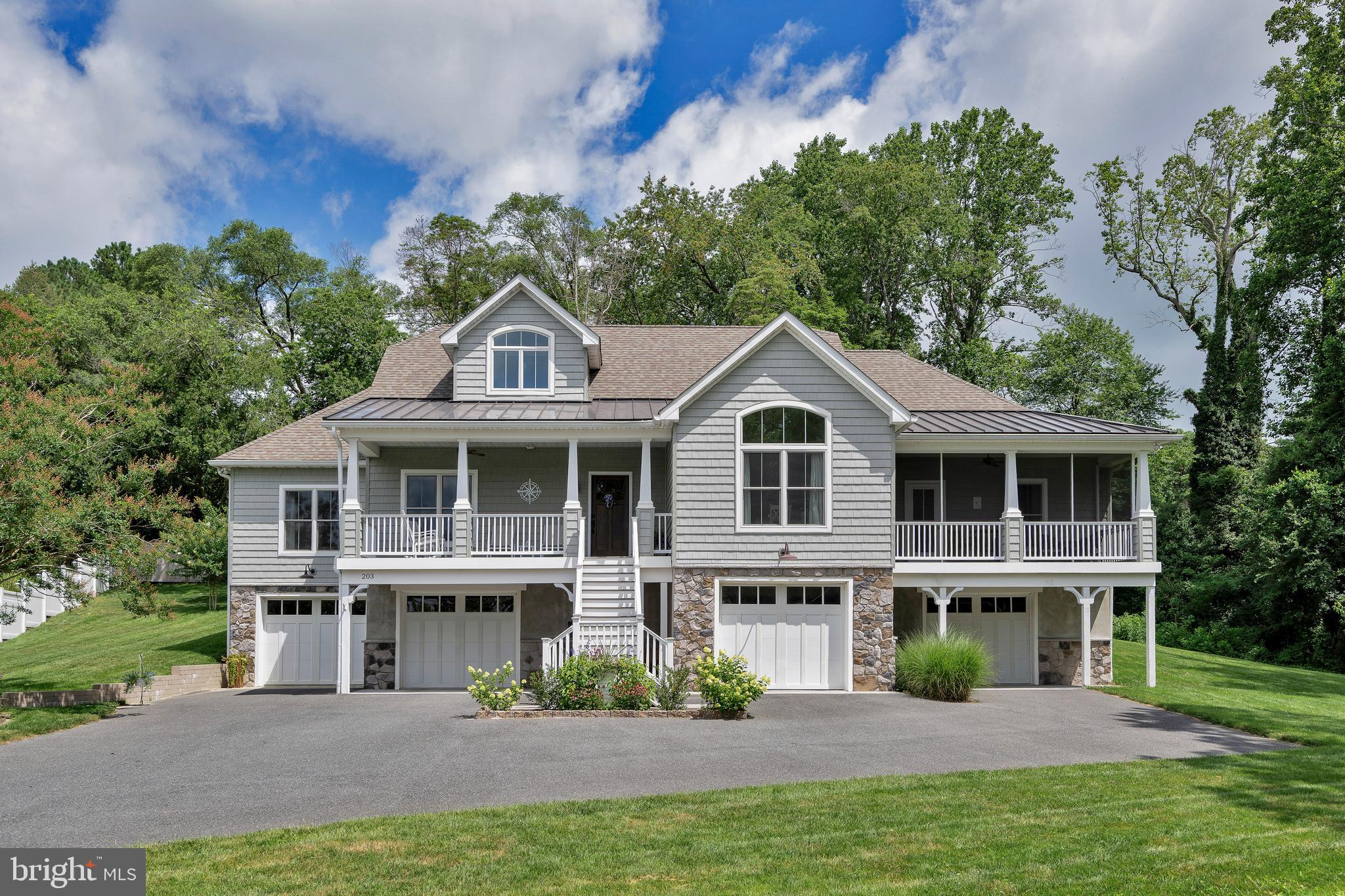 If you have dreamed of living in a small town where you can stroll to Restaurants, Theatre, Library, Shops and the Waterfront, this might be the place for you to call home.  Custom built in 2019, this Russ Palmer built home offers an open floor plan with beautiful finishes and water views. The main floor offers 3 Bedrooms and a Den/Home Office, split Bedroom Floor Plan and 2.5 Baths plus the second floor offers a Full Bath and open space now used as a playroom. This space could be used as a second Primary Bedroom . Some finishes include Hardwood Floors, Gas Fireplace, a spacious Primary Bedroom with access to your own Screened Porch which also enjoys Water Views, plus an Elevator from the garage level to the Main Floor. The bright open Kitchen includes Stainless Appliances, Granite Counters, plenty of storage as well as a large walk-in Pantry.  There is also a spacious Laundry Room with storage cabinets and sink.  In case of a power outage, relax, there is a Generator for peace of mind.   
There is also a second floor that offers a flex space that now serves as a family game room with a full bathroom.  
For the Car Collector or Craftsperson, this home offers a spacious 5 Car Garage with finished entry hall with access to the Elevator. One of the garage spaces is a Tandem style measuring 40'.
Outside, the lot that measures almost an acre, large driveway, beautiful landscaping and a spacious hard scaped patio to enjoy.  Keep your lawn lush and green with the 9 zone Irrigation system.  Relax on your covered front porch or the screened porch, both located on the front side of the home faces the 
waterfront and town owned boat slips.  The back yard area has plenty of room to add a pool too.
There is so much to take in, words don’t adequately describe this beautiful home and location.  Put this on your MUST SEE List.