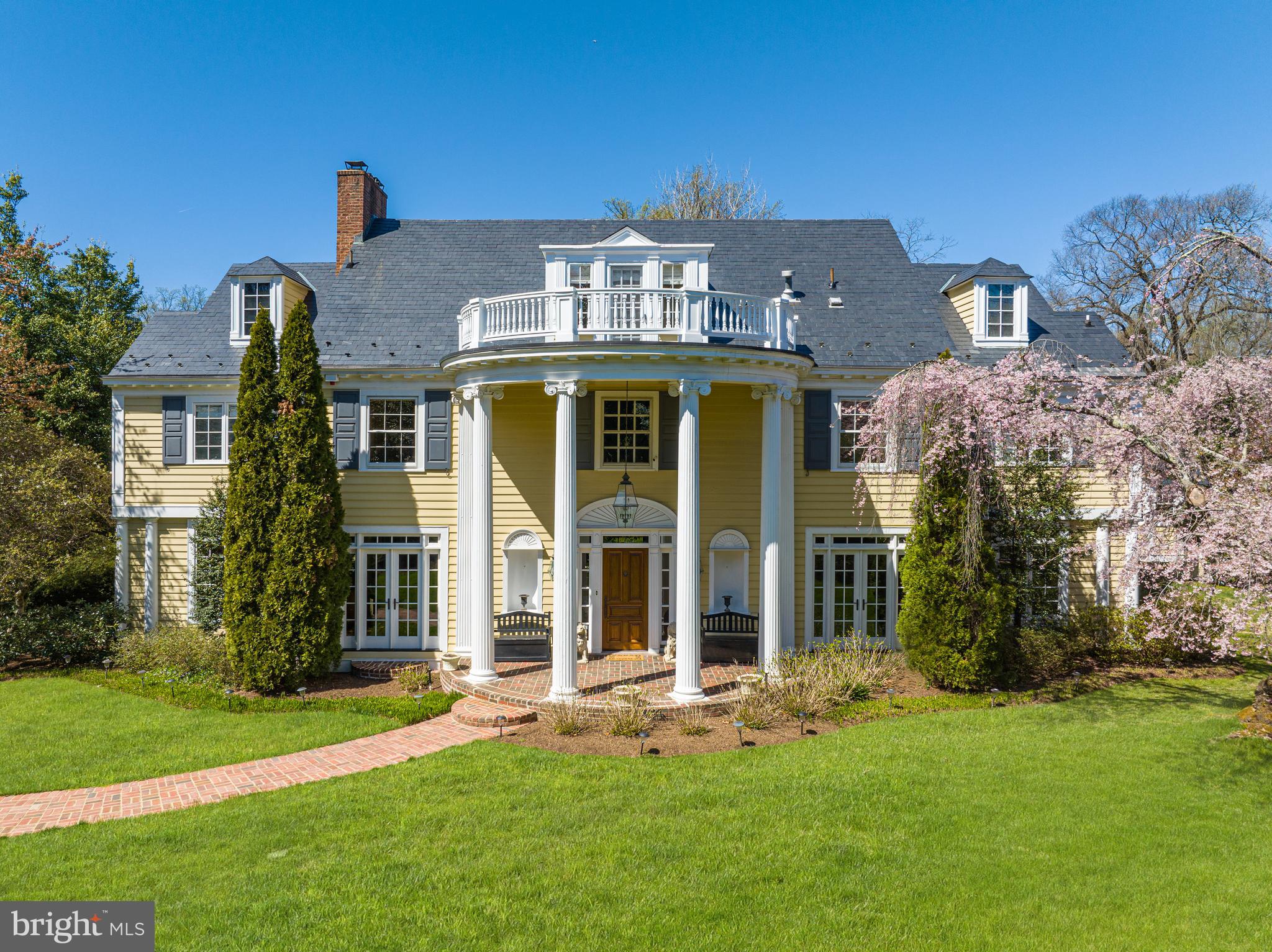 Sited on a quiet lane behind soaring natural-specimen trees, privacy abounds in this gated 1929 Colonial estate in the heart of Spring Valley. 4833 Rockwood Parkway embodies the epitome of grand scale living while privately perched in one of DC’s most desirable neighborhoods. Showcasing professionally manicured gardens, spectacular scale and impeccable craftsmanship, there is truly no estate of its kind within the District. Revered as one of Spring Valley’s oldest privately-owned single-family homes, the sprawling residence offers a harmonious blend of timeless architecture, modern finishes and breathtaking grounds to provide the pinnacle of luxurious city living. Boasting 6 Bedrooms, 8 Full Baths and 2 Half Baths across 4 finished levels and approximately 8,600 total square feet, no detail has been left untouched. Elegant design spans the residence’s perfectly appointed interiors to include magnificent millwork and endless windows, flooding the interiors with natural light while simultaneously providing a breathtaking view of the home’s stunning outdoor offerings. An expansive rear terrace surrounds the enviable 36’ Pool and offers an idyllic setting for al fresco dining and entertaining by the outdoor BBQ grill or Gazebo. 
The sun-drenched Main Level showcases the home’s principal living spaces to include a generous Living Room with wood-burning fireplace, formal Dining Room, Library, and Study complete with rich wood-paneled walls. The Gourmet Kitchen is a chef’s delight with ample tablespace, Wolf and SubZero appliances. and an adjacent Breakfast Room for more informal dining. Walls of windows and French Doors span the northwest side of the Main Level, blending the indoor-outdoor living experience and framing views of the pool, rear gardens and lawn beyond. Beautifully enclosed breezeways flank the Main Level, leading to the home’s private Guest Suite and Gazebo on either side. 
Accessible by the home’s enchanting spiral stairway, the Upper Level boasts a generous Primary Suite, featuring two separate spa-like Baths, a Dressing Room and additional walk-in closet. Two spacious en-suite Bedrooms, a Sitting Room and Office complete the Upper Level. Two additional en-suite Bedrooms and an abundance of Attic storage space comprise the Top Level’s guest quarters. The Lower Level is an entertainer’s delight, offering a cozy Family Room, Home Theatre and Wine Cellar. A Laundry Room outfitted with built-in shelving offers access to additional storage space and the home’s private, two-car Garage. Preserving the historic nature of the estate while offering the most luxurious amenities of today’s lifestyle, 4833 Rockwood Pkwy is a must-see Spring Valley retreat.