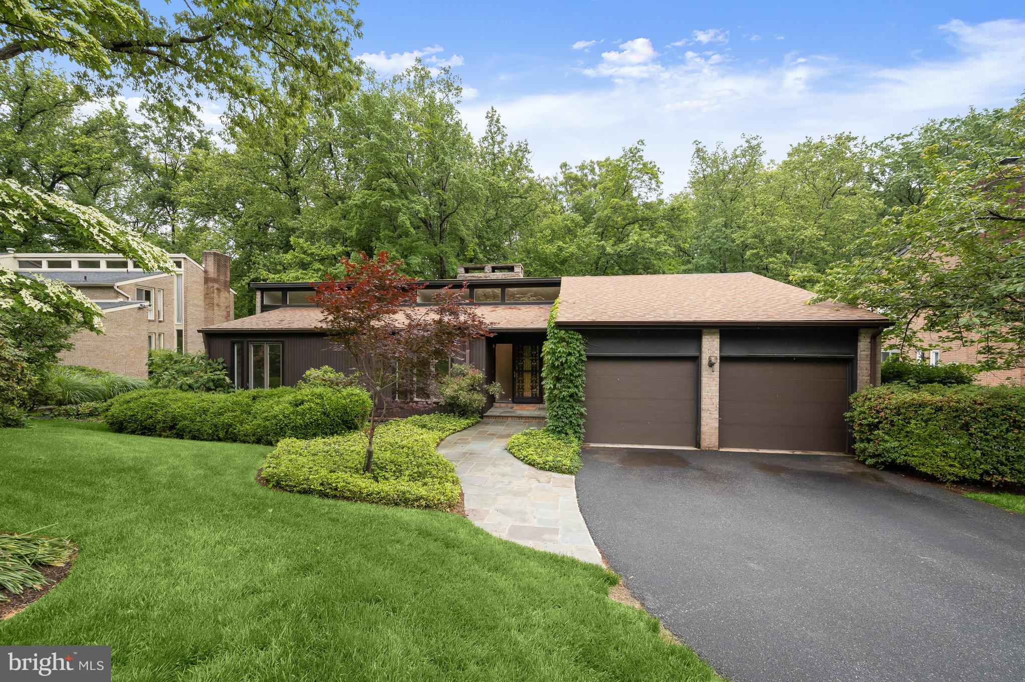 Nestled on a lovely cul de sac in the East Gate of Potomac neighborhood, 8805 Quiet Stream Court is as serene and charming as its name, offering a perfect blend of modern amenities and mid-century modern design. This popular rambler style home presents 5 Bedrooms and 3 Full Baths across 2 elegantly curated levels and 3,652 square feet of pristine living space, boasting a 2-Car, attached Garage, recessed lighting throughout and newly refinished Main Level hardwood floors.
Through the ornamental ironwork storm door, with a side, frosted window, guests and residents alike will be welcomed into the Entry Foyer, boasting a cathedral ceiling, a coat closet and new light fixture. The Living Room includes a dramatic, center stone, wood-burning fireplace, a sliding glass door to the Rear Balcony and a floating wall separating the Dining Room; host friend and family gatherings in this comforting space. The Dining Room showcases cathedral ceilings, a new chandelier and sliding glass door to the Rear Balcony. The fully remodeled Gourmet Island Kitchen boasts tile flooring, custom cabinetry, Caesarstone quartz counters, tiled backsplash, breakfast bar seating, under cabinet lighting and a picture window with Rear Yard views; the ideal craftspace for any at home chef!
The Bedroom Wing Hallway presents beautiful clerestory windows, new light fixtures and a linen closet. The Primary Bedroom includes clerestory windows as well, in addition to cathedral ceilings, a sliding glass door to the Balcony overlooking the Rear Yard, an outfitted walk-in closet, and a Primary Dressing Area, offering a granite topped vanity, framed mirrors, sconces and cathedral ceilings. The fully remodeled Primary Bath embodies a peaceful oasis, offering tile flooring, a single granite topped vanity, sconces, and a stall shower with frameless glass door, tiled flooring and surround. The Upper Level’s offerings are complete with 2 additional Bedrooms, the Second Bedroom including 2 closets, and a fully remodeled, Full Hall Bath, featuring tile flooring, a vanity with a vessel sink, and a jetted tub shower with tile surround. 
Descending the hardwood stairs to the Lower Level, the Recreation Room showcases a center stone fireplace and a sliding glass door to the Rear Patio. The Fourth Bedroom/ Office includes wood-look laminate flooring, a walk-in cedar closet and sliding glass door to the Rear Patio. The Fifth Bedroom includes wood-look laminate flooring as well in addition to full windows; host visiting family for the holidays with ease in either of these 2 inviting rooms. The Fifth Bedroom guest suite features an adjoining Kitchenette with tile flooring, a wet bar and glass tile backsplash; alongside a fully remodeled Full Bath with tile flooring, a stall shower with tiled surround, a bench seat, vanity, and Toto toilet. This Level is complete with a large Utility/Storage Room and Laundry area.

Enjoy the spring and summer sunshine on the brick Rear Patio, overlooking the private Rear Yard backing to parkland. 

In close proximity to Buck Branch Neighborhood Park and Tennis court, Falls Road Golf Course, Potomac Community Recreation Center, Cabin John Village and Potomac Village, 8805 Quiet Stream Court offers residential bliss in a sought after location!