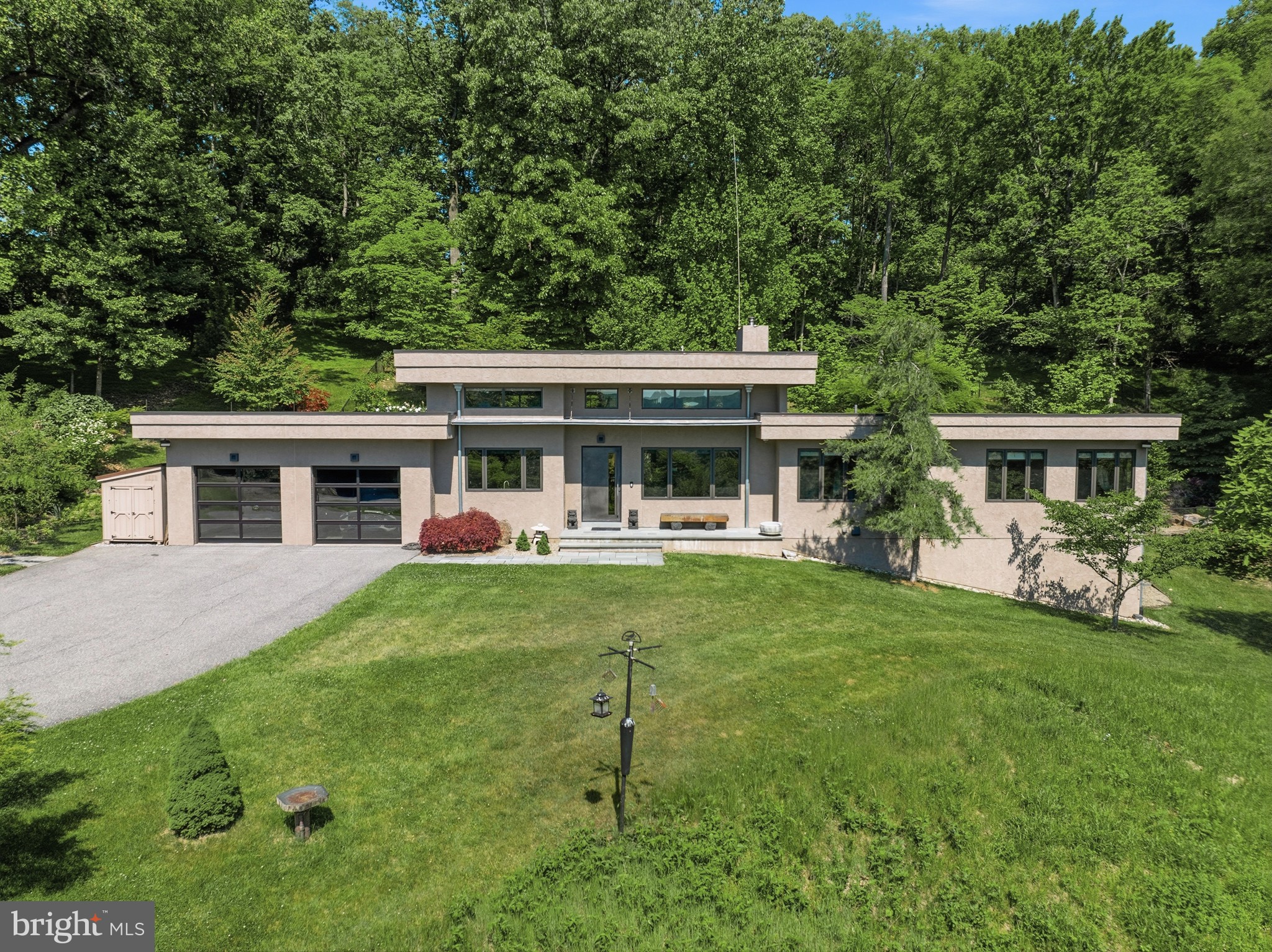 Truly a spectacular property nestled into the countryside of the Brandywine River. The property has just over 10 acres of privacy with a private gated drive to the custom Bancroft Built home with far reaching views over the Brandywine River to the wooded hillsides of the Brandywine Creek State Park. Upon entering this contemporary home, you will appreciate all the modern details married with industrial charm. The home has an open concept floor plan and radiant heated throughout with herringbone style floors on most of the main floor. The kitchen features unique man-made stone countertops, modern cabinets with hidden drawers within, gas cooktop, refrigerator, dishwasher, wine fridge and double ovens. The kitchen overlooks the main living room area with details such as floor to ceiling fireplace with woodstove, built in entertainment shelving and storage and cable overhead lighting. There is a dining room space that overlooks the courtyard garden and back of the home. Off the living room there is a separate office space. Down the hall you will find the first full bath and bedroom. Continue down the hall to the primary suite. This suite is a well sized retreat that offers beautiful views of the front yard, his and her closets and 2 linen closets. The attached primary bath is well thought out with separate vanities, free standing tub, separate toilet space and large freestanding shower. At the end of the hall is a screened in porch that is completely private and overlooks the side yard and woods. Back down the hall, down the steps to the basement you will see a built in safe, and additional finished room that is currently serving as a gym space and large unfinished walk out storage space. Back up the stairs past the kitchen there is a mud room with laundry and walk in pantry. The garage is heated with EV charger and additional storage space. The patio space is very private and has a saltwater infinity lap pool to enjoy. To the side of the attached 2 car garage is a recently built separately heated Hartley Botanic greenhouse. Down the driveway is a studio, built with Hardiboard, with a 2 car garage and workshop with half bath on the ground floor. Up the stairs you will enjoy a charming full living space with open features, cathedral ceiling, timber beams, pine hardwoods throughout, full kitchen, woodstove, 1 bedroom and 1 full bath. This space provides stunning views of the property throughout and a full trex deck for outdoor enjoyment. The last of the structures is a 2022 Dewson built Mid-Atlantic timber frame Monitor barn, also built with Hardiboard. This space has a large garage door as well as main door entry, timber frame, a shop towards the back, a half bath powder room and an old-style open elevator to the loft. There is also an antique iron staircase for access to the loft which can be used in a number of different ways. Under the barn there is covered parking for vehicles and a utility room.