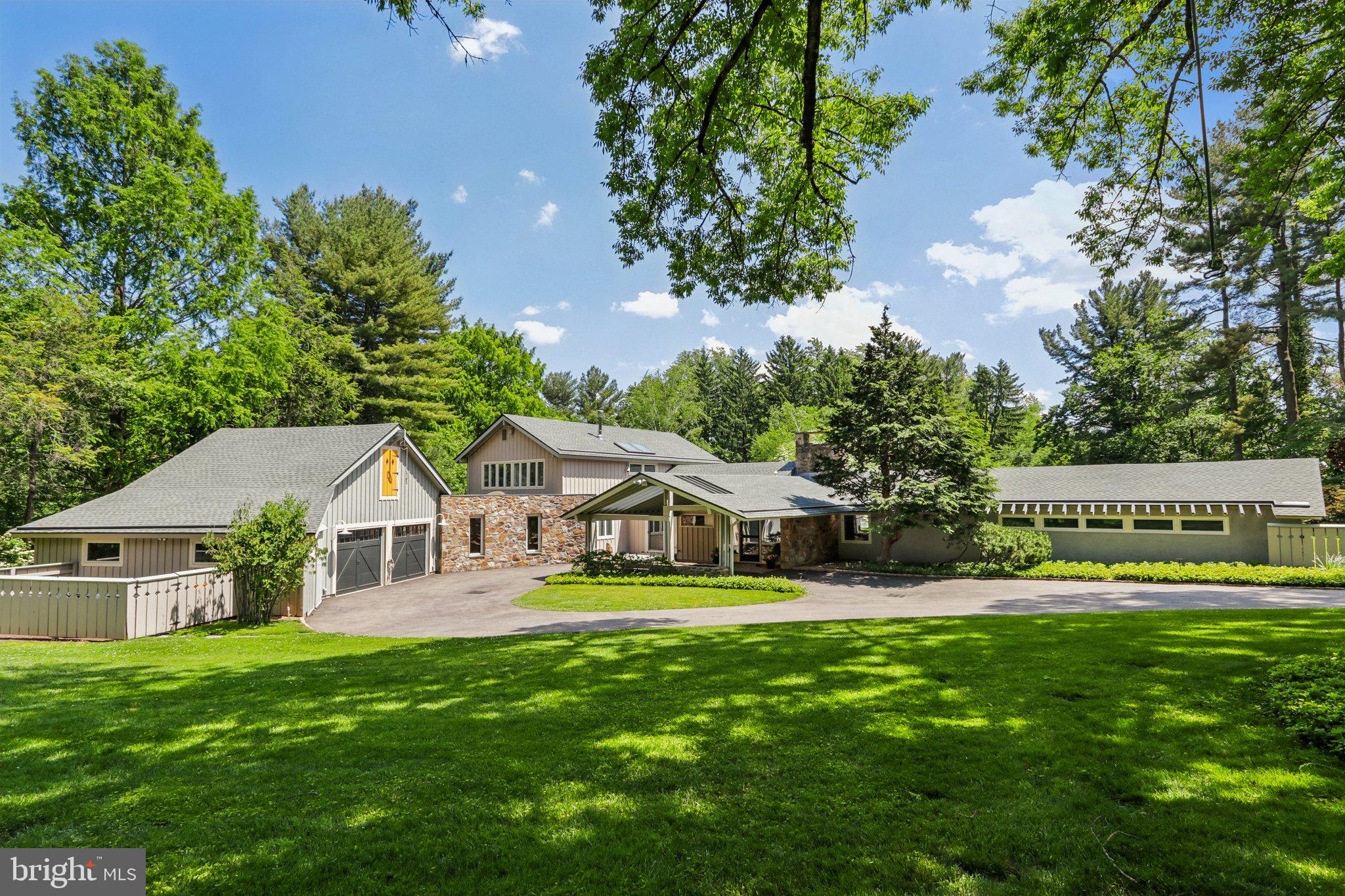 Introducing The Estate on Paper Mill, a rare private residence where architectural character, Mid-Century Modern influence, and resort-style living come together on 1.75 beautifully landscaped acres. Set in one of Meadowbrook’s most desirable locations, this distinctive 5-bedroom, 4.5-bath home offers over 4,800 square feet of living space, a saltwater pool, private tennis court, mature gardens, and exceptional indoor-outdoor living. 

A glass entry introduces the home’s striking personality and opens to a dramatic vaulted great room with soaring ceilings, a wall of windows, parquet wood floors, a gas-burning stone fireplace, wet bar, and direct access to a flagstone patio overlooking the private rear grounds. Thoughtfully oriented toward the backyard, the home is filled with natural light, garden views, and seamless access to outdoor living spaces.

The first-floor primary suite is a true retreat with serene views, a sitting room with built-in bookcases, walls of windows, multiple walk-in closets, and two separate baths. The formal dining room seats twelve and features a skylight, built-in china cabinetry, and generous storage.

The kitchen blends warmth, function, and professional-grade performance with white cabinetry, butcher block countertops, a large island with seating, vegetable sink, pantry, sitting area, window seat, and premium appliances including a 6-burner Wolf range, Sub-Zero refrigerator and freezer, Miele oven, and Bosch dishwasher. Direct access to the covered patio makes outdoor dining effortless.

Additional first-floor spaces include a family room with Amish-crafted built-in desks, a cubbied mudroom, and laundry room with Miele washer and dryer leading to a fenced vegetable garden. Upstairs, four additional bedrooms offer large windows, organized closets, and access to two full baths.

Beyond the heated two-car garage are rare bonus spaces including a bike room, workshop, garden room, and upstairs studio ideal for an office, fitness room, art space, or quiet retreat.

The grounds are the signature. Cultivated over decades, the property features mature trees, lush landscaping, flagstone paths, a fenced rear yard, saltwater pool redone in 2021, expansive lounging deck, storage/bar area, and views toward the private tennis court. Whether entertaining, swimming, playing tennis, gardening, or relaxing on the patio, this property offers a private resort lifestyle rarely found in Meadowbrook.

Additional amenities include a whole-house generator, drainage system, deer fencing, 5-zone heating and air, expanded circular driveway with carport, alarm system, tennis storage shed, and extensive storage throughout. Conveniently located near train lines to Center City, Pennypack trails, Huntingdon Valley Country Club, hospitals, and within the Abington School District.