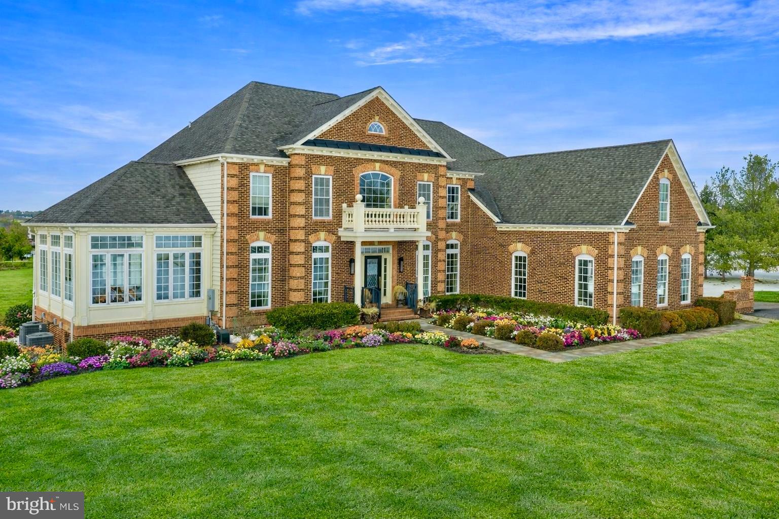 Perched gracefully on a premier corner lot, 132 Parsons Lane is a pristine 5,444-square-foot brick colonial in the heart of Newtown, PA. Thoughtfully designed and impeccably maintained, this residence blends architectural presence with refined modern comfort. A grand two-story entry sets the tone, revealing newly installed rich walnut hardwood flooring, soaring ceiling heights, and a seamless open-concept layout. Natural light pours into the conservatory just off the main hall, creating a luminous and inviting first impression.
The formal dining room transitions effortlessly into the gourmet kitchen via a well-appointed service station complete with an undercounter wine refrigerator and extensive cabinetry. The kitchen itself is both striking and functional, featuring a custom-paneled mirrored SubZero wine refrigerator, stainless steel six-burner range with hood, copper farmhouse sink, oversized marble island, dual ovens, and a spacious walk-in pantry. Whether dining beneath the crystal chandelier, gathering at the island, or entertaining on the newly installed rear deck, the space is designed for both intimate evenings and elevated hosting. The great room offers warmth and scale, anchored by a gas fireplace and a dramatic wall of windows. A private office with glass French doors, a recently updated powder room, and a well-equipped laundry room complete the main level. Upstairs, three beautifully maintained en-suite bedrooms feature newly installed custom closet systems. The Owner’s Suite is a true retreat, highlighted by tray ceiling details, soft ambient lighting, a stunning bathroom with dual vanities, a porcelain clawfoot tub, walk-in shower, and an expansive boutique-style dressing room. The fully finished lower level adds exceptional versatility with new carpeting throughout, a private gym outfitted with mirrors, and a guest bedroom and full bath with direct outdoor access—ideal for extended stays or multigenerational living. Custom brick pavers, extensive hardscaping, and manicured landscaping frame the outdoor spaces, enhancing both curb appeal and everyday enjoyment. Located within the award-winning Council Rock School District and moments from Newtown’s vibrant shopping and dining scene, this residence is just ten minutes from the river towns of New Hope and Lambertville and minutes from the beloved Wrightstown Farmers Market. A distinguished Bucks County offering, 132 Parsons Lane delivers timeless architecture, modern luxury, and an exceptional lifestyle.