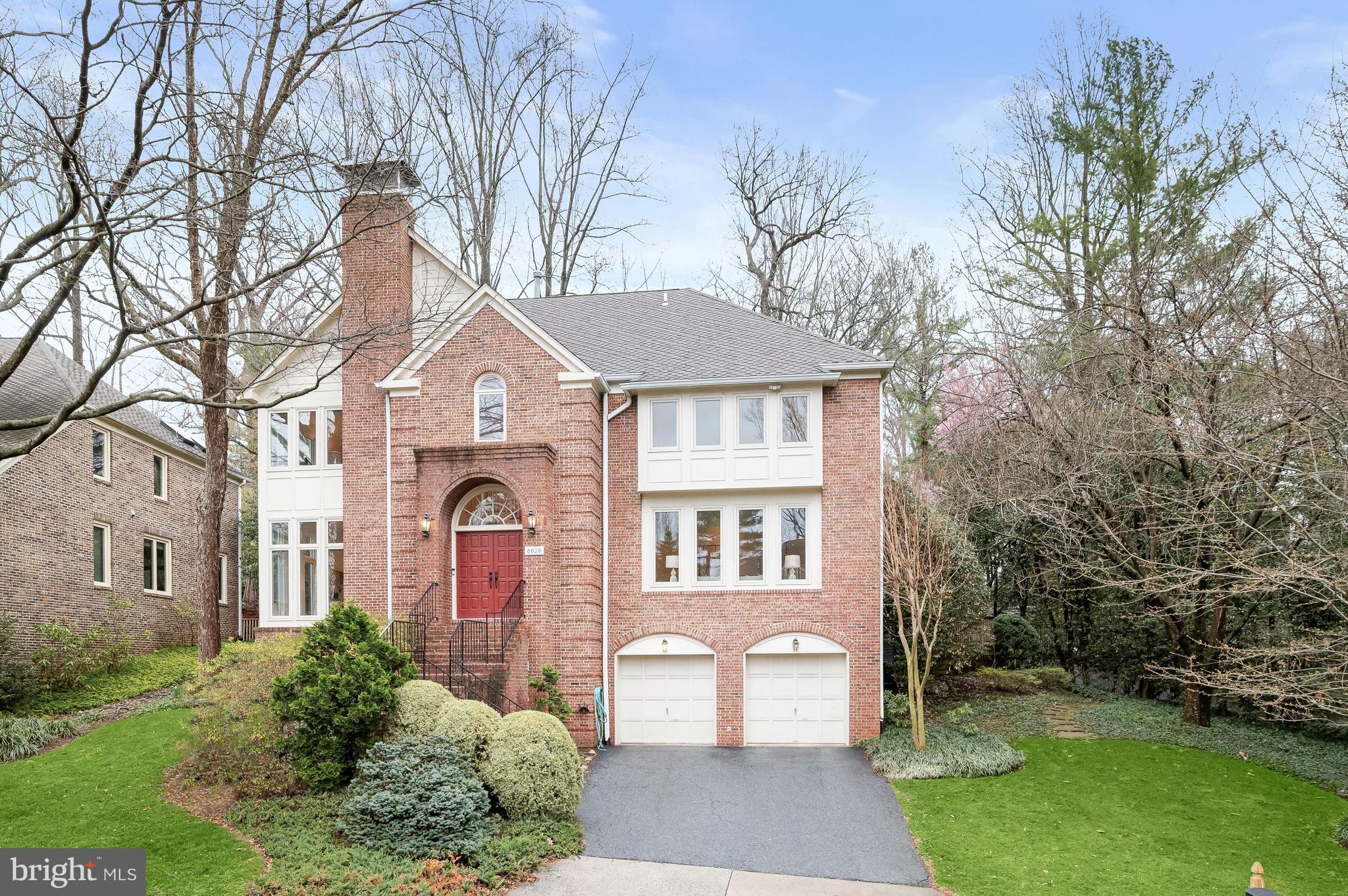 **Open House, Sunday, 2-4pm** Welcome to 6628 Landon Lane, offering an abundance of light-filled living space in an enchanting, private setting in Bethesda’s highly sought-after Locust Ridge neighborhood. Ideally situated just off River Road and moments from downtown Bethesda, the home offers the serenity of a quiet residential setting while keeping access to Washington, DC and Northern Virginia easily within reach.

A dramatic two-story foyer framed by ached windows creates a striking welcome, opening to formal living and dining rooms on one side designed for effortless flow. On the opposite side of the foyer, a family room with soaring ceilings—anchored by a wood-burning fireplace and wrapped in floor-to-ceiling windows—fills with natural light and connects seamlessly to the large eat-in kitchen. Thoughtfully appointed for everyday living and entertaining alike, the kitchen features a Thermador cooktop, Sub-Zero refrigerator, custom cabinetry with abundant storage, and a generous semi-circular island with built-in microwave. A pantry with secondary sink and washer/dryer adds convenience, while a powder room is tucked just adjacent. From the kitchen, step onto the rear flagstone patio overlooking the beautifully manicured lawn—perfect for outdoor dining and gatherings.

Upstairs, the expansive primary suite offers a serene retreat with a sitting area, wood-burning fireplace, dual side-by-side walk-in closets, and a skylit bath that brings in natural light. An additional ensuite bedroom, two well-proportioned bedrooms, and a full hall bath complete the upper level.

The lower level provides exceptional flexibility with abundant storage, a spacious recreation room, an additional bedroom, and a full bath—ideal for guests, a home office, fitness, or play space. A two-car garage with a Level 2 EV charger and plentiful storage further enhances the home’s functionality.

The location is equally compelling, situated within the coveted school pyramid of Burning Tree Elementary School, Thomas W. Pyle Middle School, and Walt Whitman High School, and the vibrancy of downtown Bethesda, 6628 Landon Lane presents a rare opportunity to enjoy space, light, privacy, and convenience in one of the area’s most desirable residential settings.