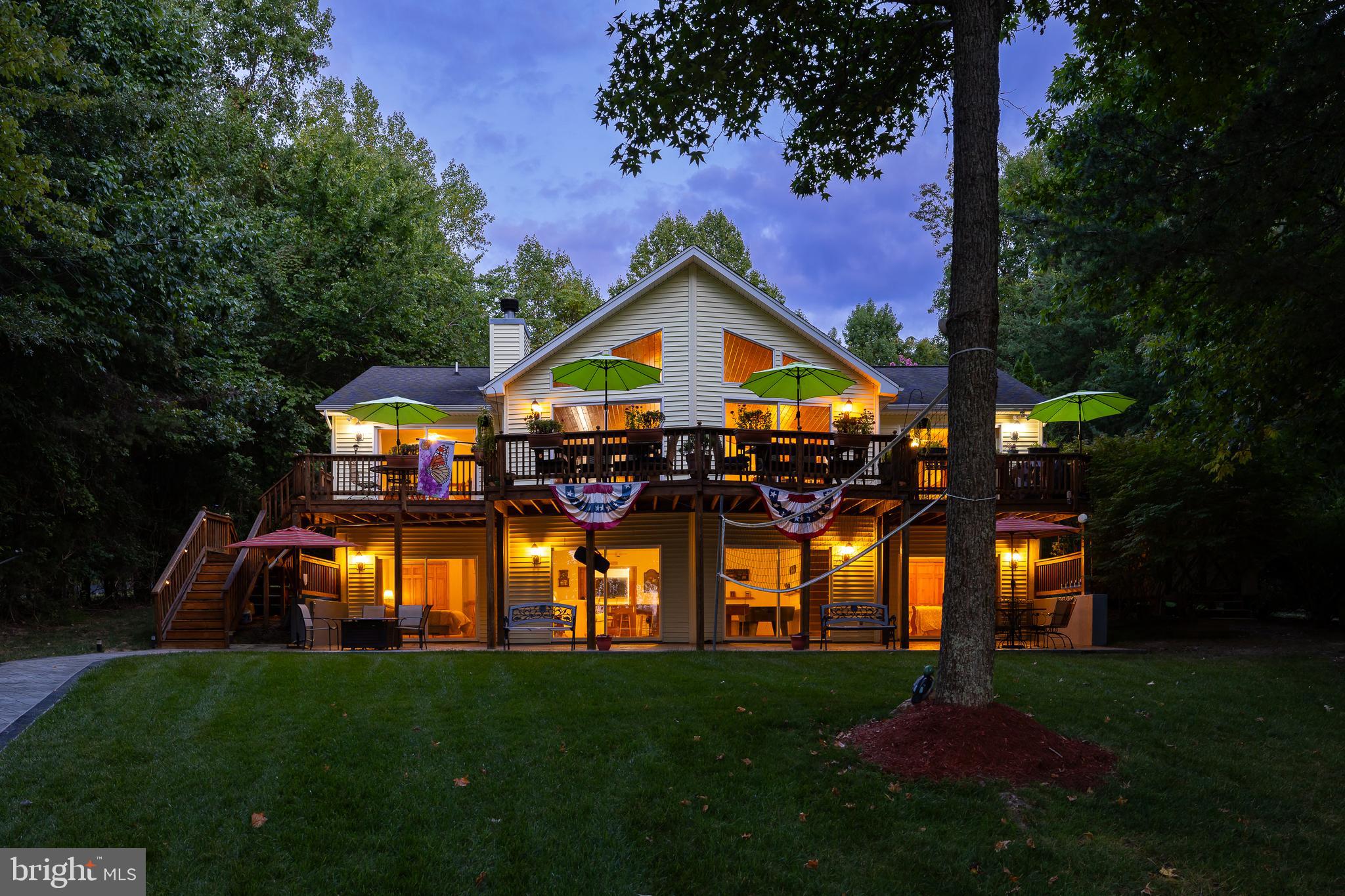 A stunning waterfront retreat located on the public side of Lake Anna, Virginia.  This turn-key home comes fully furnished, offers captivating views and is a tranquil escape from the hustle and bustle of everyday life - with no HOA!  Located on the sought-after southern end of the lake with deep clean water, in a no wake cove.   Fiber Firefly high speed internet!  Step inside to discover 3,656 finished square feet, 6 bedrooms, 4 full baths and an open floor plan perfect for entertaining your family and friends.  Vaulted wood ceilings, hardwood flooring, a stone wood burning fireplace and a wall of glass to capture the beautiful views.  The kitchen features a center island, sleek granite counters and stainless appliances.  The lakeside primary suite offers direct access to the deck, along with a walk-in closet, double vanity, and a tile shower.  There are two additional bedrooms on the main level and a full bath.  The full finished walkout basement provides extra living space with a family room, recreation area, three bedrooms, two full baths and a game room (3 bedroom septic).  Follow the beautiful hardscaping down to the water's edge to 165 feet of pristine rip-rap shoreline, your own sandy beach,  private boat ramp, and a deep water large composite boat dock (10 feet deep at end of boat dock) with an electric boat lift, two electric jet ski lifts and a sun deck to relax on and soak up the sun.  There is also a storage shed by the water for all of your lake toys and a second shed by the house for additional storage! Gather around the lakeside fire pit to roast s'mores or enjoy a cocktail and watch the sunsets.  This retreat is also nestled on a level .92 acre lot and offers great outdoor space to play horse shoes or a game of volleyball.  Paved driveway and your landscaping is nurtured by a lake-fed irrigation system, and showcased by landscape lighting at night.  Just bring your family, friends, and swimsuit and start making your memories here.  Don't miss this incredibly rare opportunity to own a waterfront home in the best location on the lake with NO HOA.  Come experience for yourself this truly remarkable, one-of-a-kind property.  You'll feel like you're at a resort everyday!  This home has been an excellent short term rental with many repeat renters and would make a great investment!