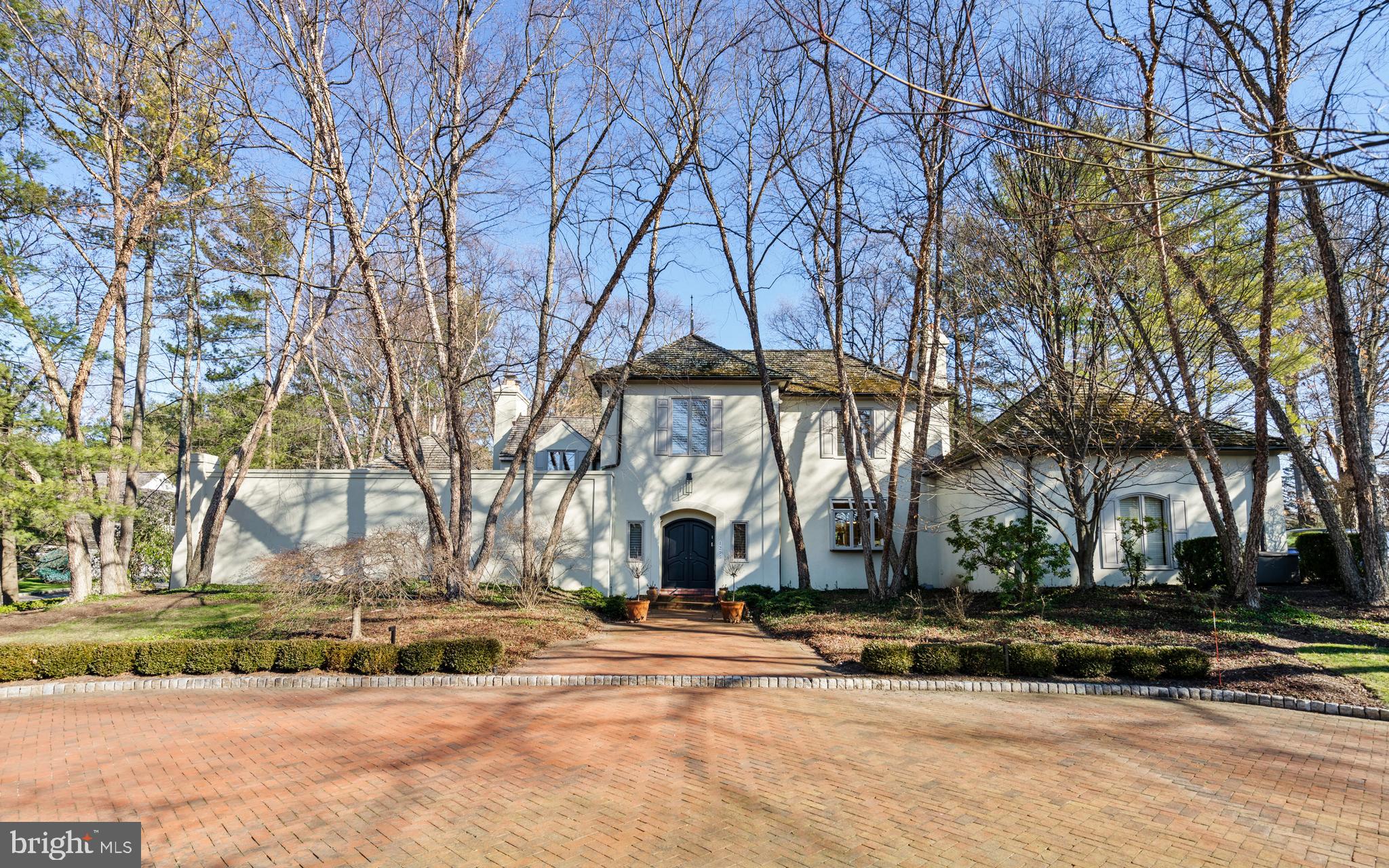 Chic, sophisticated, 3 bedroom 3 1/2 bath French Contemporary home set on a 1.1 acre parcel with Tennis Court on a premium street in Lower Merion township, is available for the first time since the home was custom built and designed by the owners in the mid 1980s.
Distinguished by vaulted ceilings, extraordinary windows and walls of sliding doors that exit to private brick terraces, the natural light in the home and the homes ‘livability’ is unparalleled. Grand entertaining spaces effortlessly accommodate parties on a large scale, while details  such as natural wood beams and a fireside Office/Tv room offer spaces for quieter enjoyment. The First Level Primary Suite is expansive. A large Dressing area, reach-in as well as walk-in Closets, and a sparkling white marble Bath, open to the volume ceiling Bedroom with handsome corner fireplace, plantation shutters and doors that open to your own private patio.Soaring ceilings in the centrally located Great Room feature a two story window to the east and opposite a sweeping staircase that leads to 2 additional Bedrooms, each with private Bath, and a second, discreet Loft/Home office. Dining happens in either the large more formal Dining Room or the adjacent Breakfast Room with both having access to the rear yard and gardens. A timeless, lacquered Siematic Kitchen enjoys views of the front brick turning circle, and mature paperbark birch trees which frame the entrance to the home. 
The Lowest Level is partially finished, offering primary storage and Recreation or Gym and mechanicals. Refined aesthetics married to practical and engaging design.