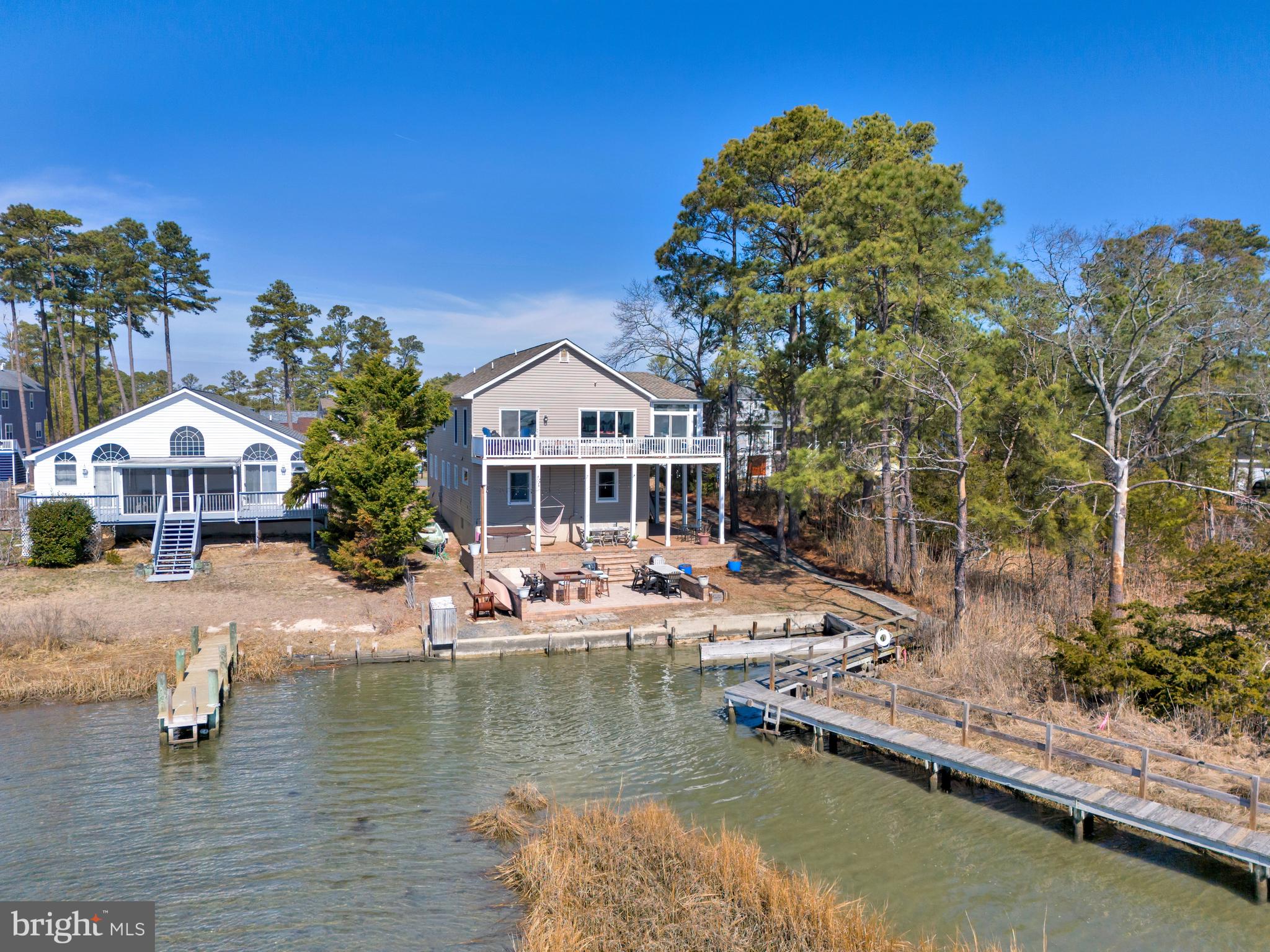 Welcome to your waterfront oasis on the stunning Indian River Bay, where breathtaking views and coastal living come together seamlessly. Perfectly positioned to capture dreamy panoramic water vistas, this exceptional home offers an outdoor entertaining space you may never want to leave.

Step outside to an expansive paver patio designed for gathering and relaxation, complete with a firepit, bar area, private boat slip, and direct dock access with a kayak launch—ideal for boating enthusiasts and those who love crabbing right from their backyard.

Inside, the thoughtfully designed inverted floor plan maximizes the views, with the main living space located on the top level. Here, you’ll find a bright and open layout featuring a spacious kitchen with an oversized island, granite countertops, and seamless flow into the dining and living areas—all framed by sweeping water views. A generously sized laundry room with ample storage adds convenience to everyday living.

The home offers 4 bedrooms and 3.5 baths across approximately 2,551 square feet. The primary suite is a true retreat, featuring private deck access, serene water views, and a luxurious en-suite bath with double vanities, a walk-in tile shower, soaking tub, and a custom closet with built-ins.

The first floor includes three additional bedrooms and two full baths, along with a separate living area—perfect for guests or multi-generational living. Two of the bedrooms enjoy beautiful water views, creating a peaceful and inviting atmosphere.

Additional highlights include a spacious two-car garage with abundant shelving for storage, low annual HOA fees, and a prime location less than a mile from Massey's Landing Public Boat Ramp, offering easy access to even more boating and waterfront adventures. Portion of the property is in a flood zone but never any flooding on property. Property was brought up 8 ft  when built.

This is coastal living at its finest—where every day feels like a getaway.