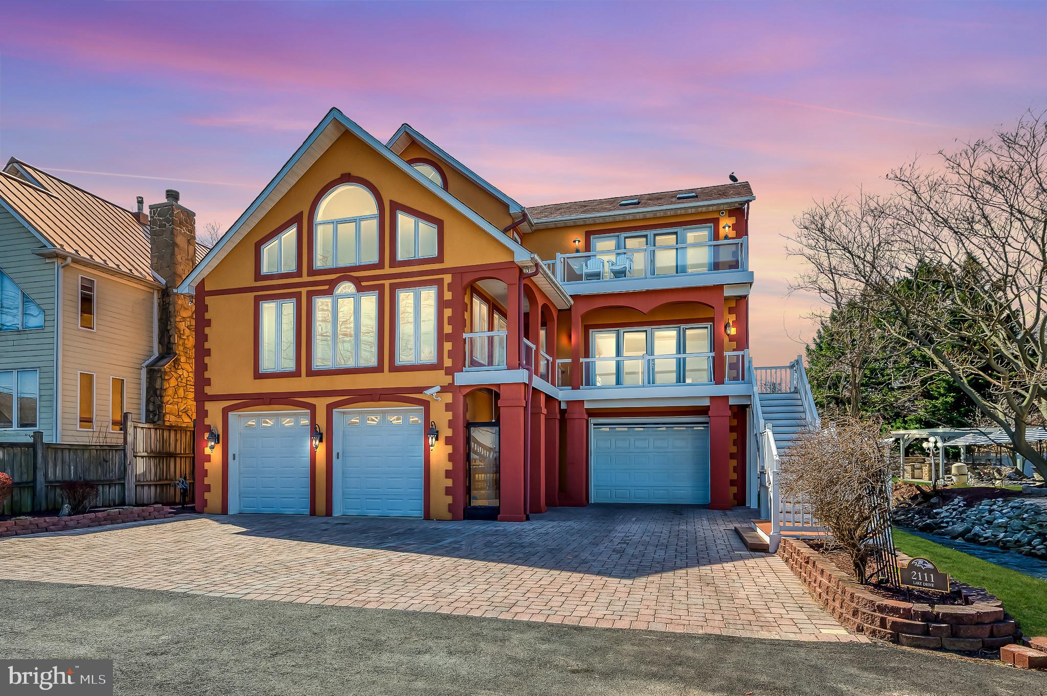 Experience the ultimate waterfront escape at this custom-designed coastal estate in Pasadena’s Bayside Beach community. With 4 bedrooms, 2 full and 2 half baths across 3,656 finished sq ft (5,652 total including garage-level recreation areas), this retreat spans 0.76 acres with 75 feet of private shoreline and panoramic views of Boyd Pond and the Chesapeake Bay. Crafted for seamless indoor-outdoor living, the home offers floor-to-ceiling windows, oversized sliders, and thoughtfully placed doors that connect you to the landscape. Over 2,600 sq ft of Azek decking and covered porches wrap the home, extending the interior with elegant spaces for open-air dining, quiet morning coffee, or sunset entertaining—all surrounded by water views and coastal breezes. At the heart of the home is a chef’s dream kitchen featuring Sub-Zero refrigeration, Viking propane range with griddle and warming shelf, Wolf oven, microwave/convection combo, fryer, steamer, and wok station. Additional highlights include a built-in food scale, double breakfast bar (seats 10), walk-in pantry with frosted glass doors, wet bar with Sub-Zero drawers, and custom KraftMaid cabinetry. Oak and tile flooring ground the space, with an 8' slider framing the view. Every detail was thoughtfully chosen for beauty, performance, and effortless function. Formal living and dining rooms offer crown molding and oak floors, while the living room doubles as a media space with a ceiling-mounted Sony projector, 92” Stewart ElectriScreen, Dolby surround sound, and multi-zone audio. A striking powder room features rough-cut granite, copper and glass inlay tile, a vessel sink, and designer lighting. It’s a perfect blend of art and utility. The showstopping two-story family room boasts cedar cathedral ceilings and a soaring river rock fireplace, flanked by walls of glass framing uninterrupted Bay views. The space is warm and grand all at once—designed for both casual nights in and large-scale entertaining. Upstairs, the primary suite is a peaceful haven with maple hardwood floors, crown molding with ambient lighting, electric fireplace, ceiling fan, two walk-in closets (including a cedar-lined option), and French doors leading to a private balcony overlooking the Bay and pool. The spa-inspired bath features a jetted tub with soapstone surround, oversized tiled shower with linen storage, granite double vanity, skylight, and custom copper and glass tilework. It’s a space designed to restore and rejuvenate. Three additional bedrooms feature maple flooring and crown molding. One includes a skylight and walk-in closet with Jack-and-Jill bath access—complete with travertine marble floors, a glass-inlaid shower, and a Sea glass vanity. Another provides quiet flexibility, while the fourth opens to a tiled balcony overlooking the family room. A second-floor laundry room offers front-loading washer/dryer, maple flooring, and a built-in ironing station. The garage level functions as a full lifestyle extension, with an oversized five-door garage and finished areas for a home gym, game room, workshop, half bath, storage, and a private sauna—offering versatile use and exceptional convenience. Outdoors, the estate transitions into a true private resort. A sparkling vinyl in-ground pool and expansive paver patio set the stage for relaxation. A fully equipped outdoor kitchen rests beneath a motorized pergola with retractable roof, perfect for year-round entertaining. A bayside firepit, sandy beach, and tiered decks and balconies provide multiple ways to unwind or host with ease. A 180-foot private pier is equipped with a 15,000-lb boat lift, jet ski swing lift, and dual electric hoists, providing effortless access to the Chesapeake Bay and all the adventure it offers. This is more than a home—it’s a statement of lifestyle. Every finish, view, and space has been carefully curated to deliver comfort, beauty, and the feeling of a getaway—every single day.