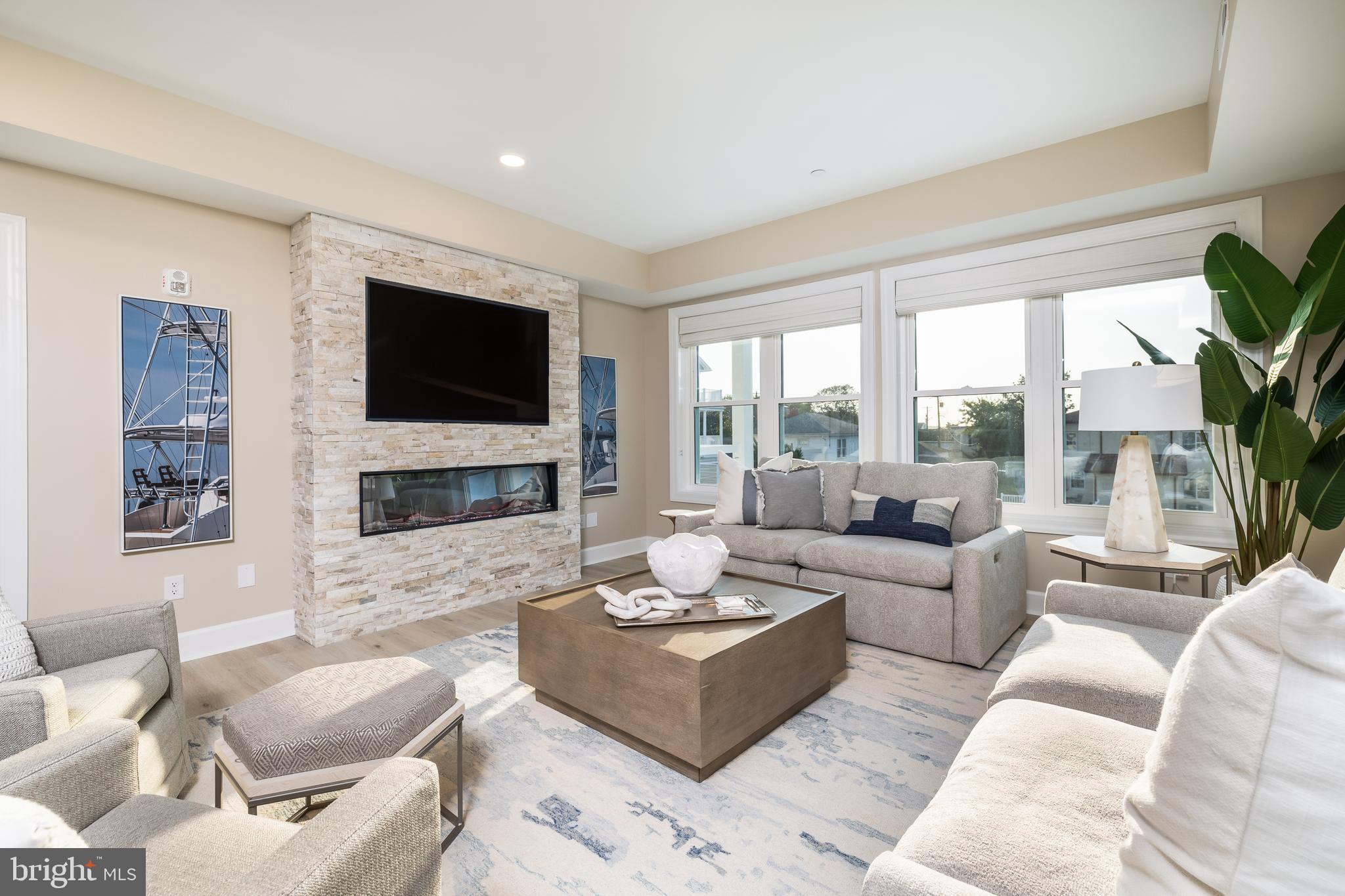 Absolutely Stunning Villas Move in ready in Ocean City! This MOVE IN READY Villa showcases an open concept perfect for entertaining! LVT through the main living areas set the tone for the tastefully designed space. Let's get cooking! Stainless Steel Appliances, White Kitchen Cabinetry with Soft Close, Quartz Countertops, Recessed Lighting, and an Electric Stove make cooking and cleanup a breeze! With so many amazing places to enjoy your meal, Morning Breakfast/ Brunch in the Dining Area or Kitchen Island, Relax with Morning Coffee on the Deck overlooking the Beautiful Bay Views. Time to unwind and Snuggle up for a movie by the Fireplace after a long day soaking in the sun. Primary Suite Boasting Walk in Closet, En - Suite with Soaking Tub, double vanity and access your private Deck.  This sprawling Villa Showcases 3 Other Bedrooms and 3 Full Baths. Not that you should ever need to leave this amazing Space but if Sunshine is what you are looking for... Take in All Ocean City has to Offer with just a short Walk to all the Major Attractions. Headed back from the beach and don't want to bring the sand inside? Rinse off in the Outdoor Shower. Covered Parking to keep your car cooler on those hot summer days! Take Advantage of dock access to our Private Boat Slips with Electric & Water available for purchase. Welcome Home to Son Ray Villas! Interior Photos are of Like Model Unit. ** Furnished Unit Options Availiable