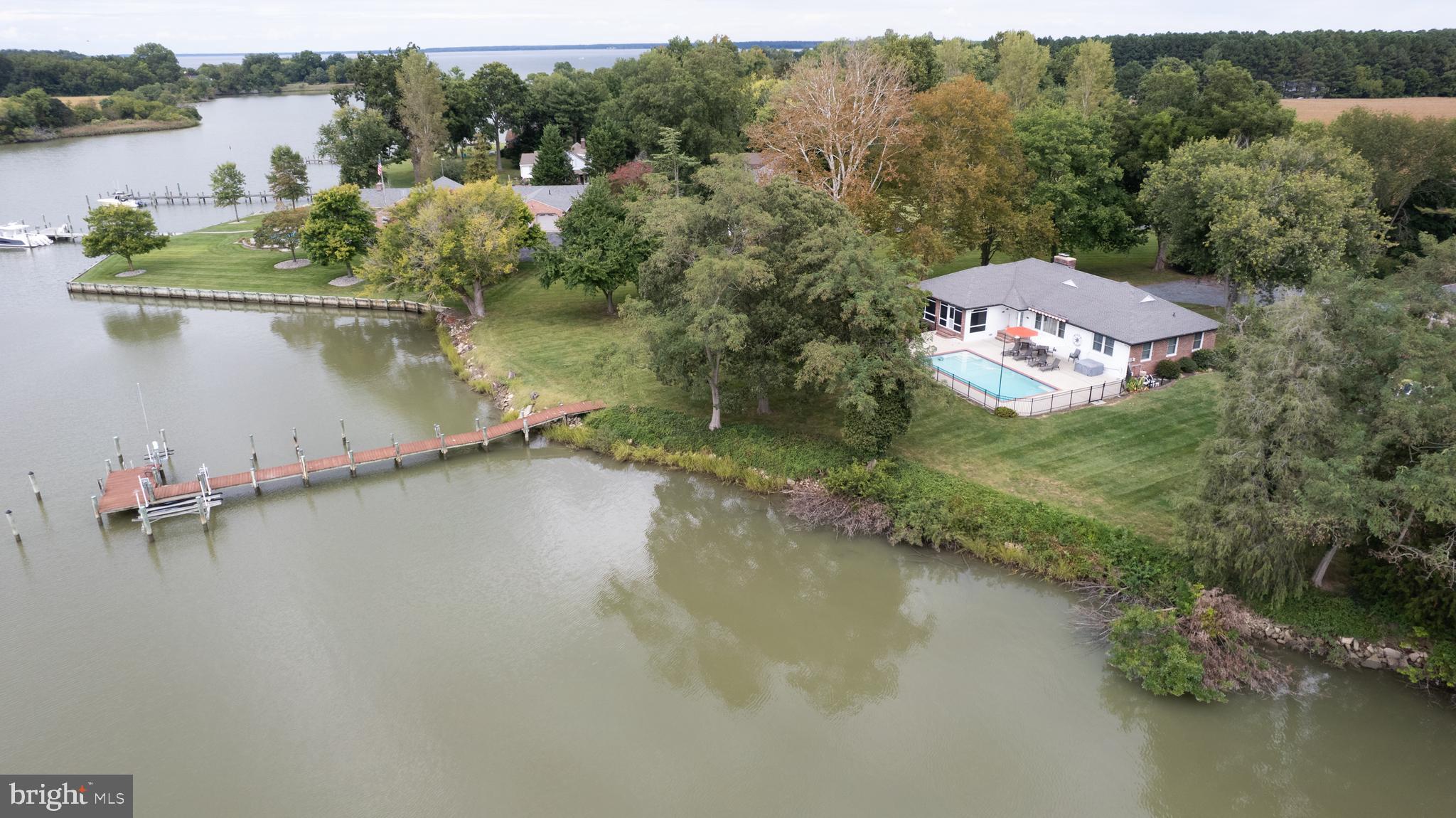 **Property Description: Waterfront Brick Rancher with Stunning Sunsets**

Welcome to your dream waterfront retreat! This charming brick rancher features 3 spacious bedrooms and 2 full baths, perfect for a vacation rental or your forever home. 

As you step inside, you'll be greeted by stunning hardwood floors that flow throughout the home. The inviting living room boasts a brick wood-burning fireplace and picturesque views of Jenkins Creek, creating a cozy atmosphere for relaxation. Enjoy breathtaking sunsets from the comfort of your living space as the day winds down.

The den, complete with built-in shelves, offers a great space for reading or a home office. Enjoy formal dining in the elegant dining room, which features sliding doors that lead to a screened porch, ideal for entertaining while overlooking the in-ground pool and the serene water views, perfect for sunset gatherings.

The updated kitchen is a chef's delight, featuring laminate countertops, a large farm sink, an electric cooktop, a wall oven, a microwave, and a refrigerator with an ice maker. The generous walk-in pantry ensures ample storage space for all your culinary needs. 

Conveniently located, the laundry room includes a washer and dryer, a tub sink, and an additional toilet. 

The primary bedroom offers a tranquil view of the pool and creek, along with double cedar closets for all your storage needs. Its accompanying bath features ceramic tile flooring and a stall shower. 

Two additional bedrooms are well-appointed, one measuring 13’ x 11’ and the other 12’ x 11’, both with cedar closets for a touch of warmth and character. 

Step outside to the concrete patio that surrounds the in-ground pool and hot tub/spa, complete with a Sun Setter awning for shade on sunny days. 

For water enthusiasts, the property includes a pier with electric and water access, along with a boat lift and a jet ski lift, making it easy to enjoy life on the water. 

With gorgeous sunsets painting the sky every evening, this waterfront brick rancher offers the perfect blend of comfort, style, and outdoor adventure. Don’t miss your chance to own this incredible property!