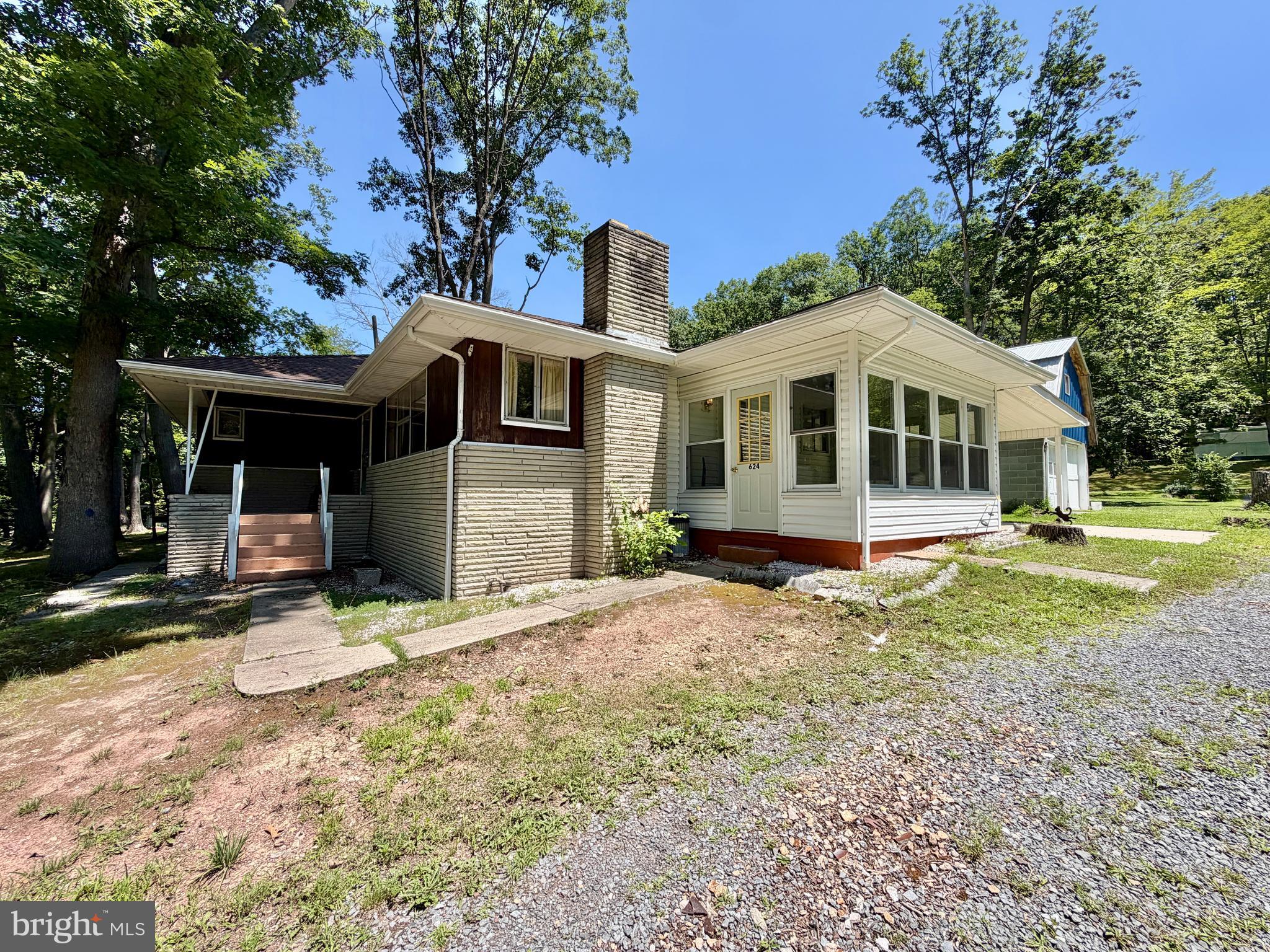 Well-maintained ranch-style home located just outside of town. The main floor features three spacious bedrooms and 1.5 bathrooms, a welcoming living room with picture windows that fill the space with natural light, an eat-in kitchen providing a great place for meals and gatherings. Throughout the home, you'll find hardwood floors and marble window sills that add a great touch. The full basement offers generous storage options or the potential to create additional rooms. It also features a laundry area equipped with a shower and utility sink. Outside, enjoy an enclosed sun-room, a covered front porch, a large carport that could serve as a covered patio for outdoor dining or lounging, and a two-story, two-car garage for parking and storage needs. An adjacent 32'x57' garage with mobile home and a bungalow-style home are also available to be purchased.