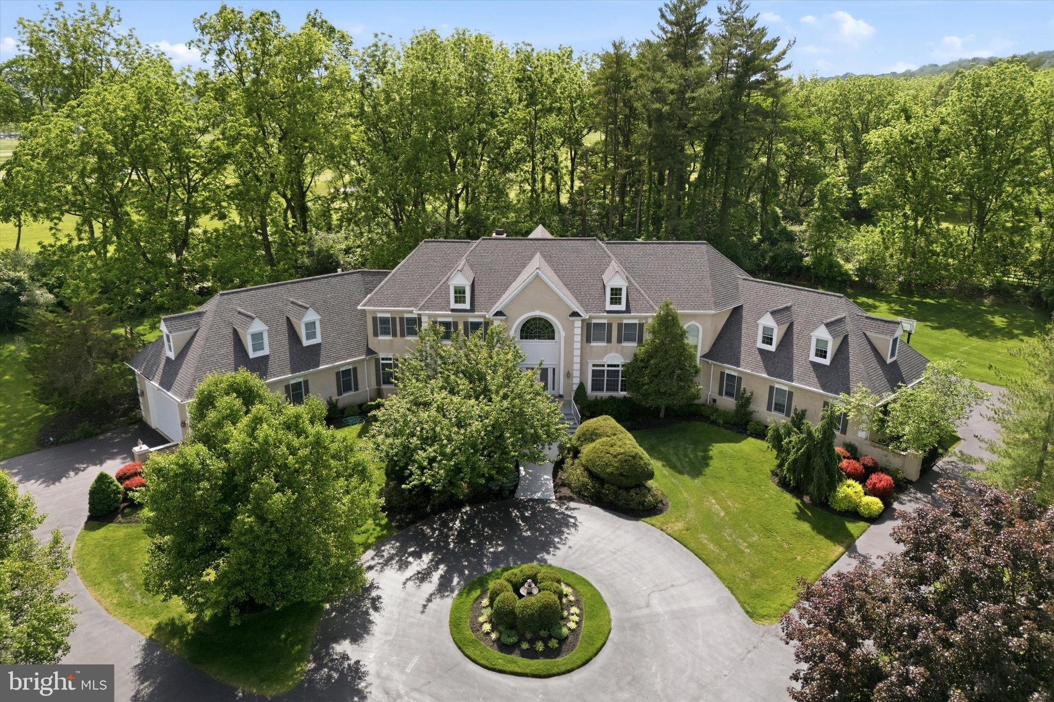 Welcome to 5 Wingate Court, an exceptional French Normandy–style residence gracefully positioned at the end of a quiet cul-de-sac in the coveted Country Club Estates. Set on nearly two picturesque acres bordering the Philadelphia Cricket Club golf course, this elegant home offers 5 bedrooms, 4 full and 2 half baths, and approximately 5,959 square feet of thoughtfully designed living space, with an additional 2500 square feet in the finished lower level. A grand two-story foyer sets the tone for the home’s timeless appeal, leading to a step-down living room with fireplace and an inviting formal dining room. The expansive great room features a fireplace and custom bar, creating an ideal setting for both entertaining and everyday living. A distinguished library with custom cabinetry offers a refined workspace, while the adjacent solarium fills the home with natural light. The gourmet kitchen with fireplace, breakfast area, and butler’s pantry is truly the heart of the home. A well-appointed laundry room and two powder rooms complete the main level. The second level is highlighted by an expansive primary suite with a private sitting room, fireplace, spa-inspired en-suite bath, and three walk-in closets. Three additional bedrooms, two full bathrooms, and a private office provide ample space for family and guests. The fully finished lower level enhances the home’s versatility with a bedroom, full bath, and flexible living space. A walk-up attic offers additional storage or the option for future expanded living space. Outdoors, a beautiful flagstone patio overlooks the sweeping grounds, offering a serene backdrop for outdoor entertaining. The attached three-car garage, along with an extraordinary boat garage, provides exceptional flexibility—ideal for a car collection, golf simulator, sport court, or hobby space. Ideally located near the Green Ribbon Walking Trail, Fort Washington State Park, and the shops and restaurants of Flourtown and Chestnut Hill, with convenient access to Routes 309, 476, and the Pennsylvania Turnpike.