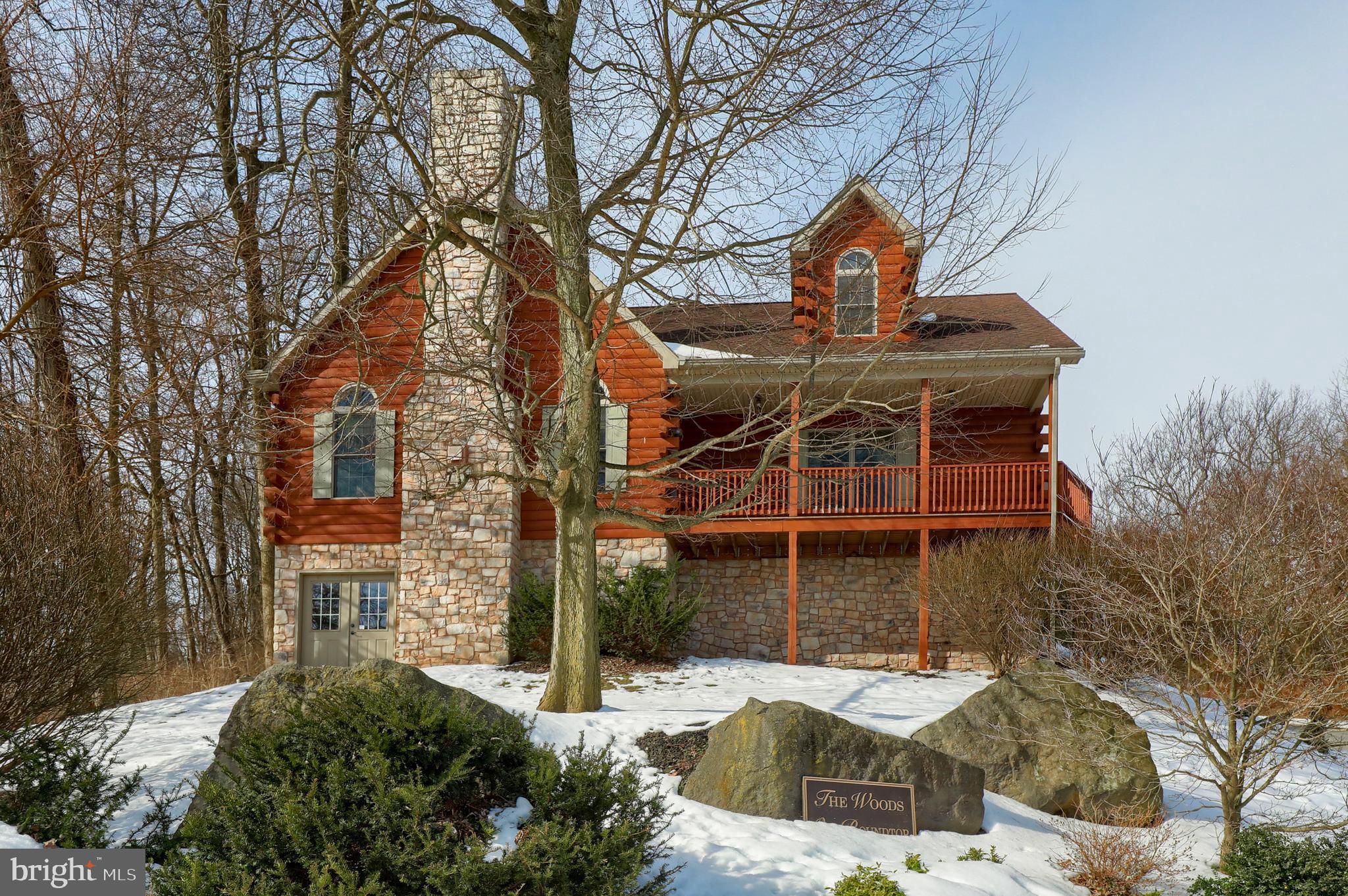 NESTLE INTO THIS BEAUTIFUL LOG-SIDED HOME IN THE WOODS AT ROUNDTOP.   WALK INTO A SPACIOUS LAYOUT WITH CATHEDRAL CEILINGS AND OPEN RAILING STAIRS GIVING YOU A VIEW INTO THE DINING AND KITCHEN AREAS.  WITH WARM HARDWOOD, STONEWORK AND A SPACIOUS OPEN LAYOUT SHOWCASED BY PLENTY OF NATURAL LIGHT, THIS HOME IS A PERFECT BLEND OF “COZY CABIN” AND ELEVATED LANCASTER LIVING.   CURL UP NEXT TO THE WARM FIREPLACE OR GATHER WITH GUESTS AROUND THE ISLAND IN THE LARGE KITCHEN FEATURING A LARGE EAT-IN DINING SPACE. JUST OFF THE KITCHEN, THE LAUNDRY/MUDROOM PROVIDES ADDED STORAGE AND PASSAGE INTO YOUR OVERSIZED TWO-CAR. THE BRIGHT, OPEN LOFT UPSTAIRS OVERLOOKS THE BEAUTIFUL FLOOR-TO-CEILING STONE HEARTH ACCENTUATING THE FIREPLACE IN THE GREAT ROOM DOWNSTAIRS.  TWO LARGE BEDROOMS AND THE FULL BATHROOM ON THE UPPER LEVEL GIVE THE FAMILY A PERFECT PLACE TO CALL THEIR OWN WHILE YOU RETREAT INTO THE LARGE MAIN-LEVEL MASTER BEDROOM FEATURING ITS OWN GAS FIREPLACE AND ON-SUITE BATHROOM.     AN ADDITIONAL ROOM NEXT TO THE MASTER BEDROOM CAN BE UTILIZED AS AN OFFICE, NURSERY, SMALL BEDROOM OR JUST PERSONAL SPACE FOR ARTS, CRAFTS OR HOBBIES. ENTERTAIN FRIENDS IN LL FAMILY ROOM AREA WHERE YOU CAN CREATE YOUR OWN BILLIARD/GAME ROOM OR CREATE A HOME THEATRE AREA WHERE YOU CAN ENJOY MOVIE NIGHT WITH FRIENDS AND FAMILY. THERE ARE ENDLESS POSSIBILITIES IN THE ADDITIONAL FINISHED SPACES ON THE LOWER LEVEL.     ACRES OF WOODED LAND SURROUND YOUR .78-ACRE LOT SITUATED ON A PRIVATE ROAD SERVING ONLY 8 HOMES.  KICK YOUR FEET UP WITH A WARM CUP OF COFFEE AND TAKE IN THE VIEW OF THE WOODS FROM YOUR PRIVATE SCREENED-IN PORCH OR BE CAPTIVATED ON THE WRAP AROUND PORCH TAKING IN THE VAST SCENIC VIEWS!    ENJOY HAVING EASY ACCESS TO THE BEST OF LANCASTER FROM A QUIET NEIGHBORHOOD THAT FEELS RESERVED JUST FOR YOU.