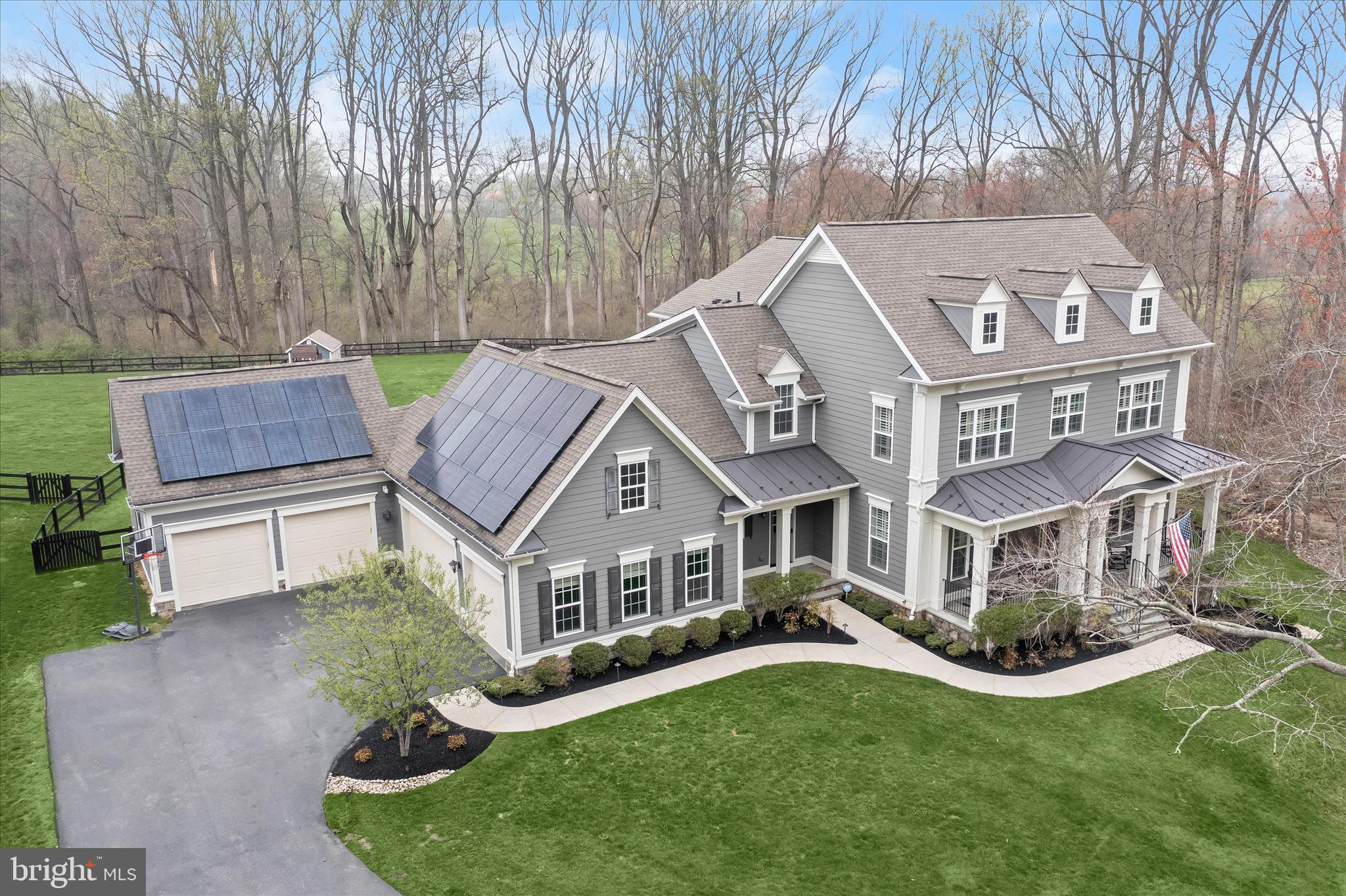 Welcome to 12240 Pleasant Springs Court - a premier offering in the exclusive enclave of Highland Reserve. Built in 2018, this Hawthorne model crafted by acclaimed home builder Mitchell & Best boasts 5 bedrooms, 4.5 bathrooms and more than 6,200 total square feet of refined living space. Sited on a fully-fenced picturesque one-acre lot with a breathtaking wooded backdrop, yet just minutes from the modern conveniences of Maple Lawn - this property presents a rare opportunity for privacy coupled with the most ideal and coveted location in Howard County. Parking will never be a problem with a five-car garage and lifts allowing for up to seven vehicles. Fully owned solar panels make for greatly reduced energy bills and three valuable Tesla Powerwalls are already installed. In the backyard, a custom playground and storage shed are waiting for the kids to enjoy.  

The interior is as functional as it is elegant offering plantation shutters and wide-plank hardwood flooring throughout. The designer kitchen with all the most up-to-date accoutrements features white shaker-style cabinetry with a contrasting light gray center island and butler pantry. The coffered ceiling and gas fireplace in the living room make it the heart of the home, while the eat-in breakfast nook leads to the TREX deck outside. More plantation shutters and hardwood flooring await on the upper level where you’ll find a sprawling primary suite offering a wall of windows and an expansive walk-in closet. The primary bath boasts two vanities, a soaking tub, and a spacious shower stall. Two of the secondary upstairs bedrooms share a bathroom while the third bedroom has an en suite bath all its own. The walk-out lower level is flooded with natural light and boasts a custom wet-bar in the main recreation room, fully loaded home gym, large play room, guest room, full bathroom, and French doors leading to the paver patio outside. Don’t miss your chance to own one of the finest residences to become available in Howard County.