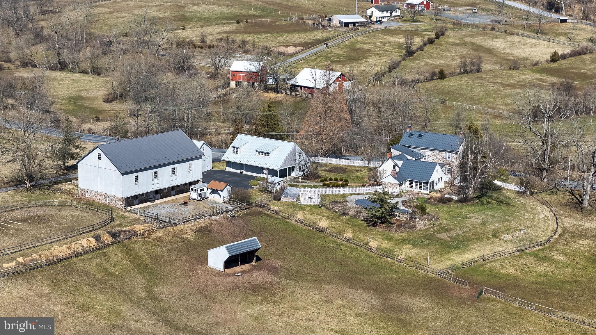 Welcome to Meeting House Farm, a scenic gentleman’s farm set on approximately 7.35 serene acres in Exeter Township School District offering a rare blend of historic character, thoughtful updates, and versatile multi use space. Believed to date to the late 1700s, this stone and stucco residence reflects a mix of preserved architectural detail and modern comfort in a setting that invites a quieter, more intentional way of living.
Inside, the home features exposed beams, original woodwork, solid maple window sills, and multiple fireplaces that have been inspected during current ownership. A skylight lit hallway leads to a spacious kitchen designed for both everyday living and entertaining offering a substantial center island with secondary vegetable sink, granite countertops, extensive cabinetry, stainless appliances including double wall ovens and a propane cooktop, a beverage refrigerator, and a light filled breakfast area with oversized windows and doors opening to the brick patio and pool setting.
The main level offers a variety of formal and casual living areas including a living room with fireplace, dining space, den previously believed to have functioned as a smokehouse, a private office featuring solid wood built in bookshelves, and additional flexible use rooms suitable for hobbies or creative pursuits. The finished attic has been adapted as an office space complete with built in cabinetry and two skylights providing natural light.
Outbuildings enhance the property's flexibility and may appeal to those interested in equestrian or hobby farm pursuits with features that include fenced pasture areas, a sand based riding ring, run in areas, and a circa 1840 bank barn (40x70) with four stalls, tack room, and updated upper level flooring. A two story wagon barn (30x20) with large double doors may offer storage, workshop, or studio potential. Additional accessory structures include a pool house and a well house with electric service and copper roof. For peace of mind, this home also includes a propane powered back-up generator. 
Above the heated three car garage, a finished apartment offers vaulted ceilings, kitchenette, steam shower, two Murphy beds, and access to sauna and outdoor shower suitable for guests, extended living arrangements, or other permitted uses.
Outdoor living includes a saltwater Gunite pool with stone waterfall feature surrounded by an expansive brick patio ideal for relaxing or entertaining. Beyond the home, the acreage opens into peaceful tree lined spaces for gardening, animals, recreation, or simply enjoying open space and fresh air, with Monocacy Creek running along the tree line of the property. Sustainability and nature are at the heart of the grounds, which boast a productive organic garden and apple, pear, and peach trees.
Whether your vision includes hobby farming, creative workspace, or a private country retreat, the grounds and layout may accommodate a variety of lifestyle needs. A rare opportunity to own a historic property offering character, versatility, and a peaceful setting in Birdsboro.