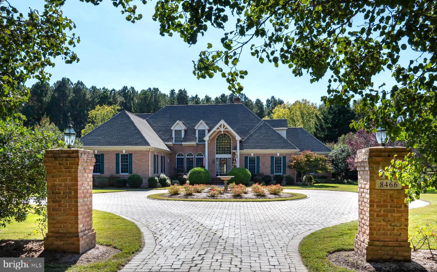 This private retreat, ideally positioned between historic Easton and St. Michaels, offers the rare combination of privacy, acreage, and refined living that buyers seek on Maryland’s Eastern Shore. Set on more than six beautifully landscaped acres, the property includes a striking 4,800‑square‑foot all‑brick Colonial residence, an expansive concrete pool with a screened entertainment pavilion, a versatile 60' x 30' Morton building, and frontage on a freshwater pond with peaceful views extending toward the Miles River.  The residence was just connected to our county sewer system which provides ultimate flexibility for future expansion of the home if desired.   *  The home’s exterior is designed for low‑maintenance living with full brick construction, a new roof, a paved drive and circular turnaround, generous parking, brick walkways, and a concrete pool surround. Inside, the first floor features oak hardwood floors, high ceilings, and impressive room sizes. The living room with fireplace, formal dining room, and private office or den with powder room create an elegant and functional layout. The renovated gourmet kitchen includes granite countertops, a tile backsplash, stainless appliances, and opens to a breakfast room and a spacious family room with a vaulted ceiling and cozy fireplace. The first‑floor primary suite serves as a true retreat with a vaulted ceiling, fireplace, oversized walk‑in closet, luxurious bath, and an adjoining flex room ideal for a gym, office, studio, or hobby space. A well‑designed mudroom, laundry with cabinetry and sink, and an additional powder room connect conveniently to the oversized two‑car garage.  *  The second floor offers a private guest suite with its own bath, two additional bedrooms, a hall bath, and a large bonus or game room. Dual staircases — a formal front staircase and a back staircase leading to the kitchen and family room — enhance both convenience and privacy.  *  Outdoor living is a highlight of this property. The large concrete pool and screened pavillion create an inviting setting for warm‑weather enjoyment. Mature, thoughtful landscaping surrounds the home, while the Morton building with four overhead doors provides exceptional flexibility for boats, RVs, car storage, or workshop needs. The freshwater pond at the edge of the property adds a serene natural element, with pondside views stretching toward the Miles River.  *   The home has been meticulously maintained and significantly improved. Recent upgrades include a renovated kitchen and dining area with new fixtures, backsplash, wallpaper, and stainless appliances; a 5‑ton Carrier high‑efficiency heat pump  for 1st floor installed in 2011; Bryant 2.5‑ton upstairs AC unit installed in 2018; 2023 electric hot water heater; fresh exterior painting of the house, cabana, and barn trim in 2016; and a new GAF Weather Stopper 50‑year roof with transferable warranty added in 2018. The Morton building received a new steel roof in 2019. An 18.6 kW grid‑tied solar array was installed on the barn roof, covering approximately 90 percent of the home’s annual electric use. Atlantic Broadband service was extended to the property for reliable internet access. Additional enhancements include custom mosquito curtains for the cabana, a new pantry under the stairs, a fully remodeled downstairs bath, and an upgraded primary bath with new double vanity, granite, fixtures, and mirrors. Extensive landscaping improvements include new trees, raised garden beds with irrigation, refreshed poolside plantings, a new picket fence with hydrangeas and iris, and upgraded perennial gardens featuring a wide variety of seasonal blooms.  Quarterly public sewer fee $231.25.