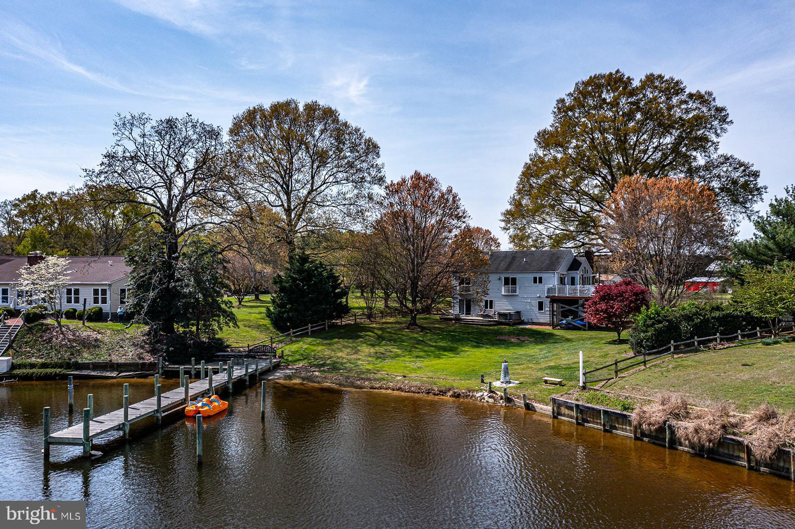"Stunning River Retreat" turn key tri-level home on a protected cove, featuring a deep-water pier which was rebuilt in 2019, multiple decks, fenced in yard, a hot tub, game room, and a wet bar. All furniture conveys including the hot tub, pool table etc. There are two sets of washers and dryers. The garage is currently set up as an additional sleeping area. This house is perfect for family fun on the river! The community does have a boat ramp.