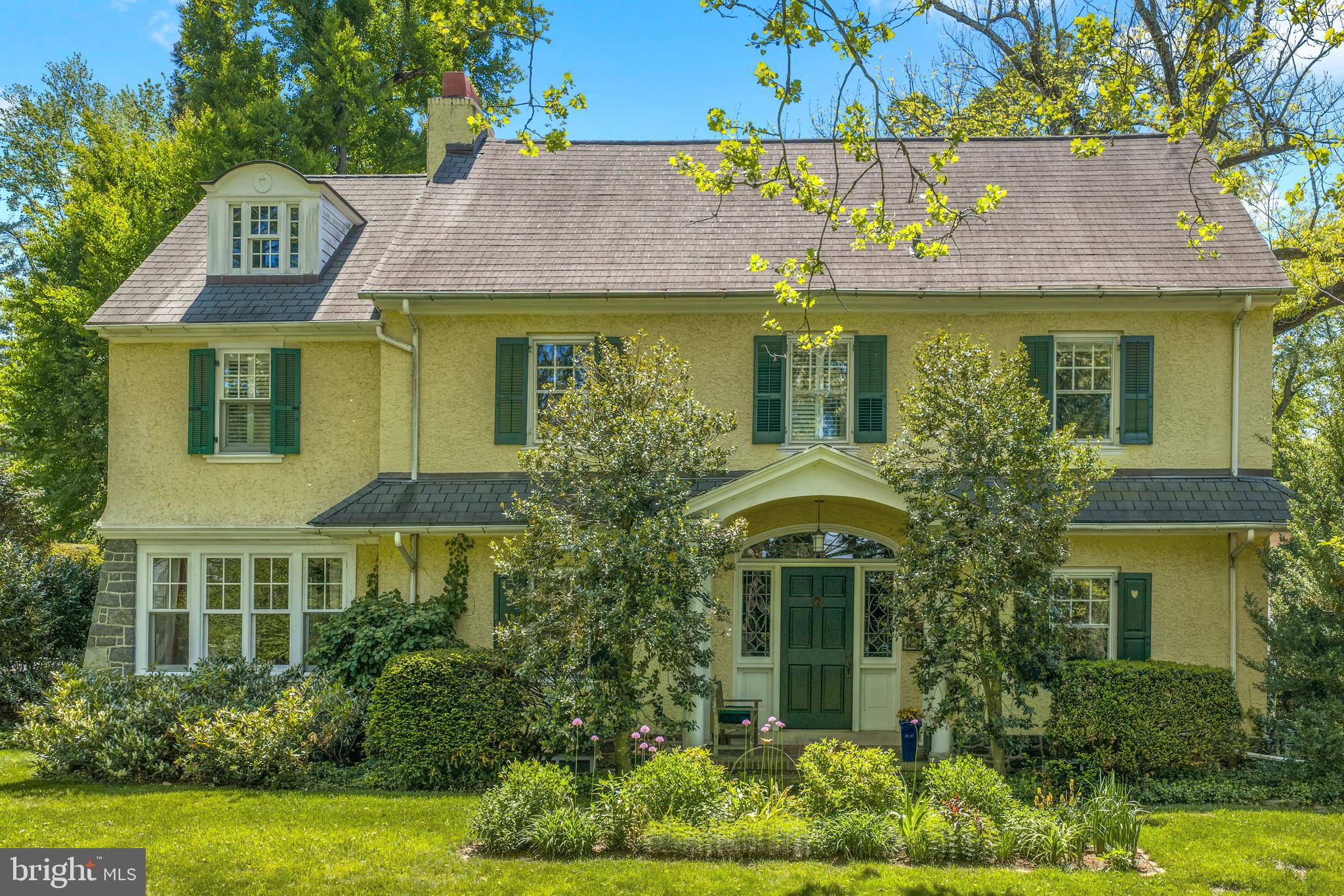 This beautiful and truly timeless home is steeped with character, warmth, and charismatic detail. From the moment you arrive, the lush green lawn sets the scene — mature trees, layered gardens, and a peaceful, forest-like backdrop create an atmosphere that feels both private and magical. A canopy of blossoming greenery gently draws you toward the home, where classic architecture and thoughtful details immediately capture your attention.
Inside, sunlight pours through beautiful arched windows, casting a soft glow across gleaming hardwood floors and highlighting the home’s exceptional craftsmanship. Elegant wainscoting, and carefully preserved architectural details give every room depth and personality. At the heart of the home, a stunning wood-burning fireplace anchors the living space, creating the perfect setting for cozy evenings and effortless entertaining alike.
The spacious yet intimate layout flows naturally, offering airy, connected living spaces while still allowing for quiet retreat. Across four bedrooms and four baths, the home unfolds with comfort and grace, each room framed by windows that invite the surrounding greenery inside and create a seamless connection to nature. Just beyond the enchanting backyard, with garden house and playhouse, a tucked-away path leads directly to the Radnor Trail, offering the rare balance of outdoor adventure and peaceful privacy.
While rich in timeless character and architectural charm, the home has also been thoughtfully enhanced with modern conveniences that make everyday living effortless. A Sonos sound system brings music seamlessly throughout the home, while multiple heating and cooling zones provide personalized comfort in every season. Outside, the lush, meticulously maintained landscape is supported by a full irrigation system and beautifully accented by elegant exterior lighting that transforms the property after sunset. Practical luxuries have been equally considered, including an electric car charger, a heated section of the driveway for winter ease, and a home security system that offers peace of mind. The result is a home that gracefully blends classic beauty with comfort and functionality - truly special at every turn.  From the Radnor trail , the property is a short, scenic and safe walk to downtown Wayne, and the train station! The essence of Main Line life!!